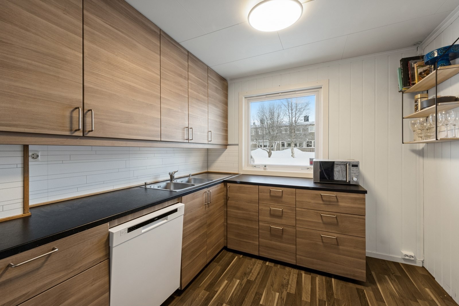 Kjøkkenet fremstår som moderne og innbydende. Her er det rikelig med skap og benkeplass Galleribilde