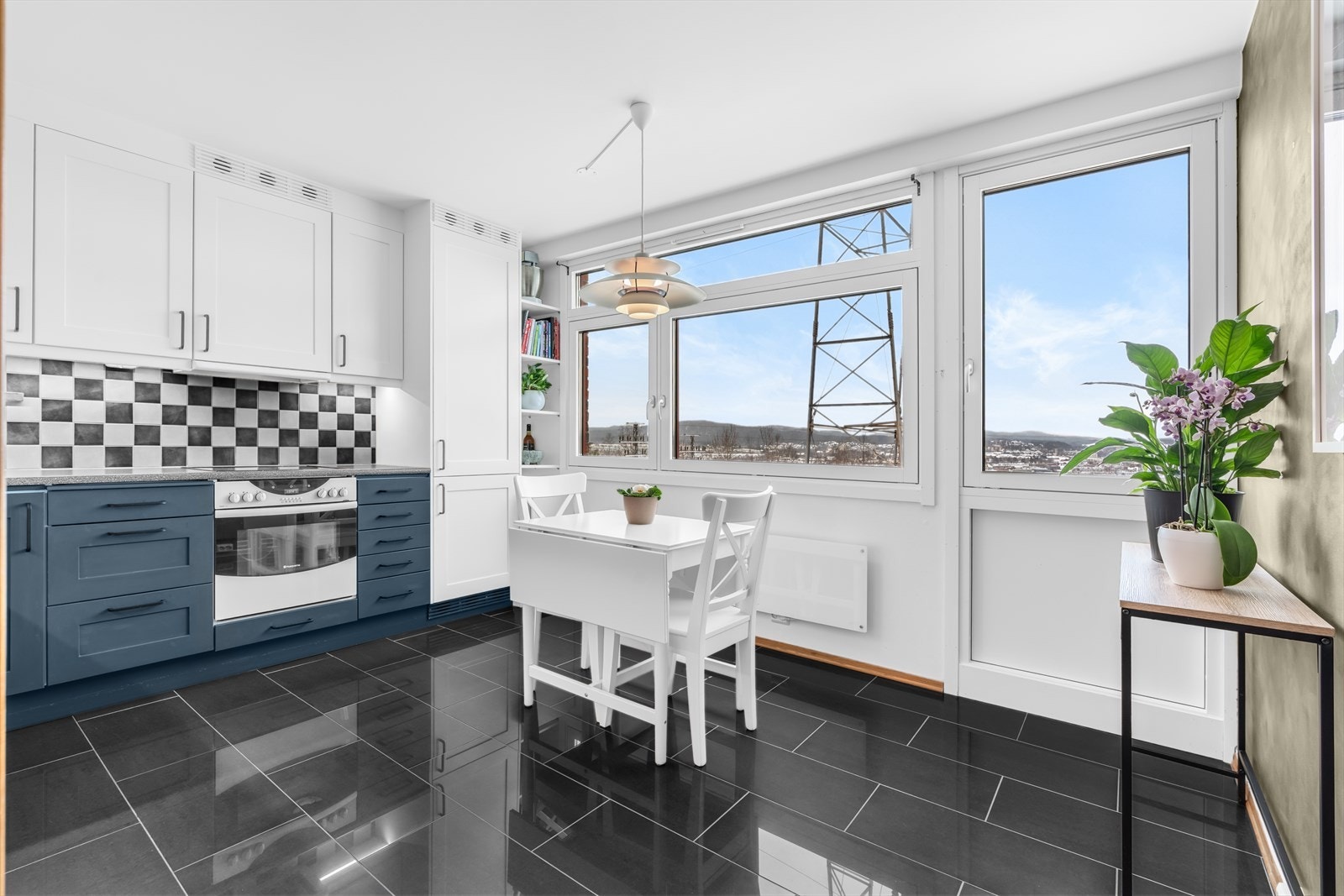 Kjøkkeninnredningen har profilerte fronter som ble malt i 2019, og fliser over benken. Galleribilde