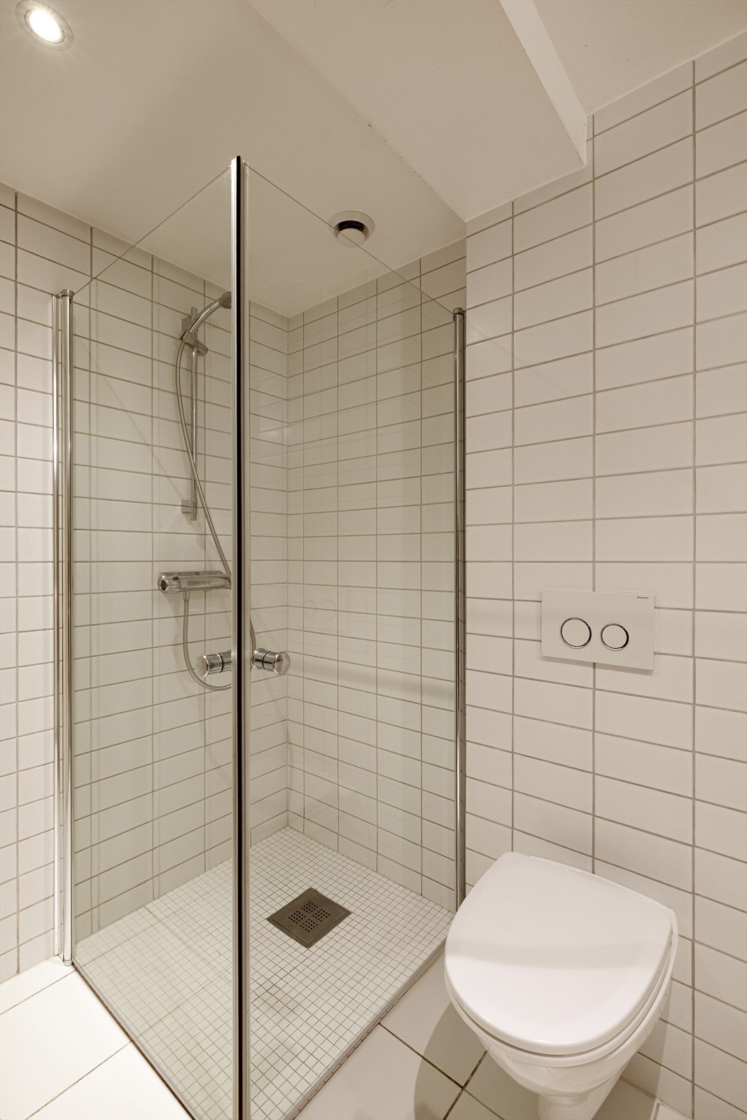 Innredningen består av en servantseksjon med nedfelt servant, vegghengt toalett, nedsenket dusjhjørne med glassvegger og opplegg for vaskemaskin. Galleribilde