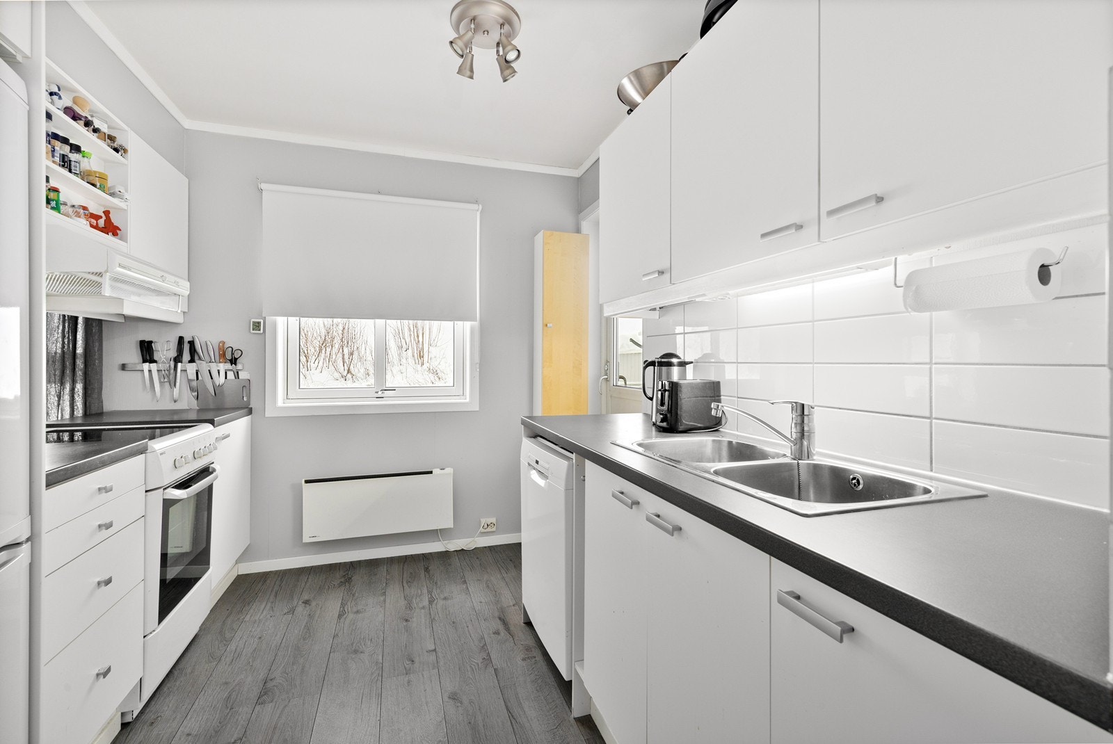 Kjøkkenet er utstyrt med en innredning med slette, folierte fronter og en benkeplate i laminat. Galleribilde