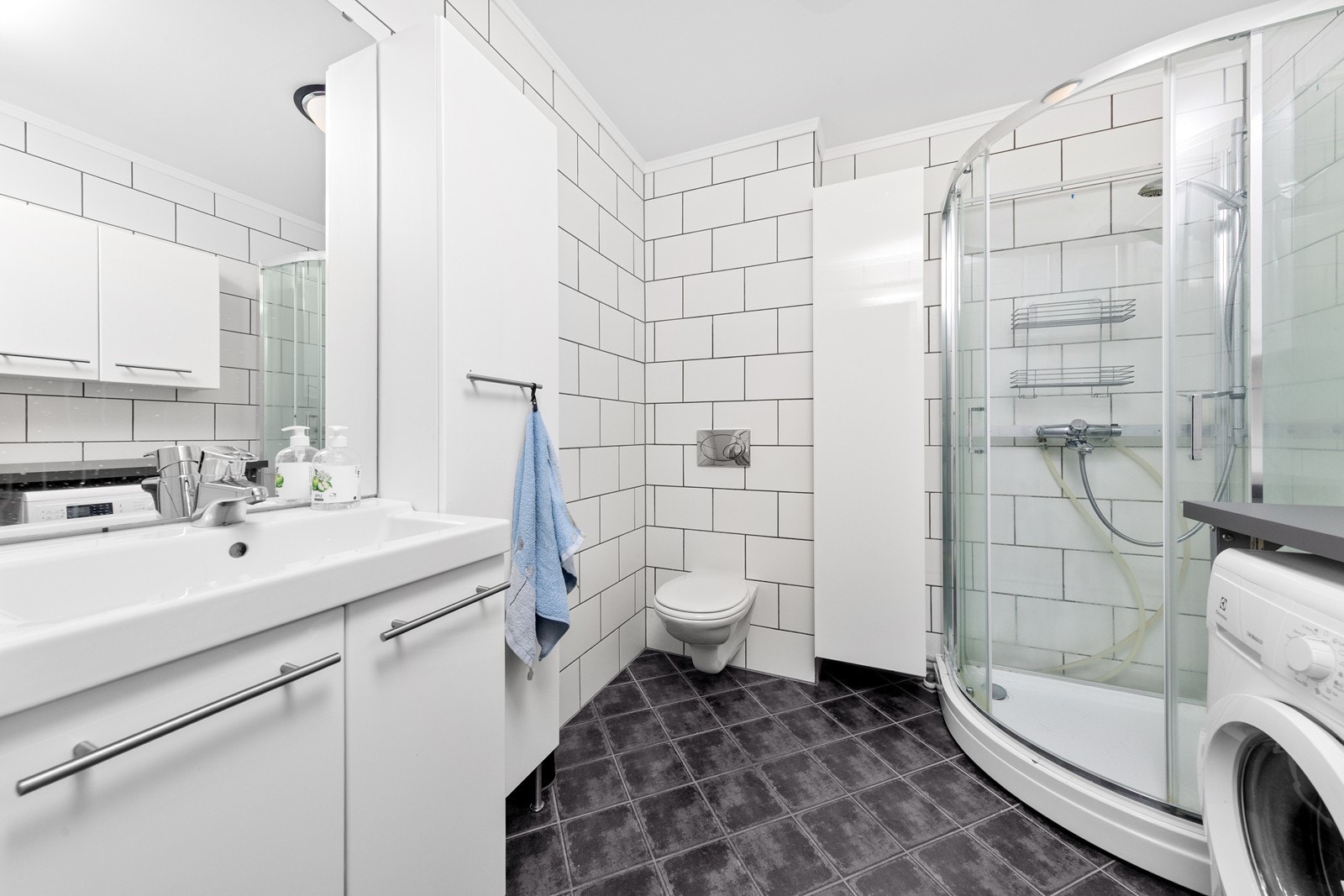 Badet er tidløst og fliselagt med komfortabel elektrisk gulvvarme. Galleribilde