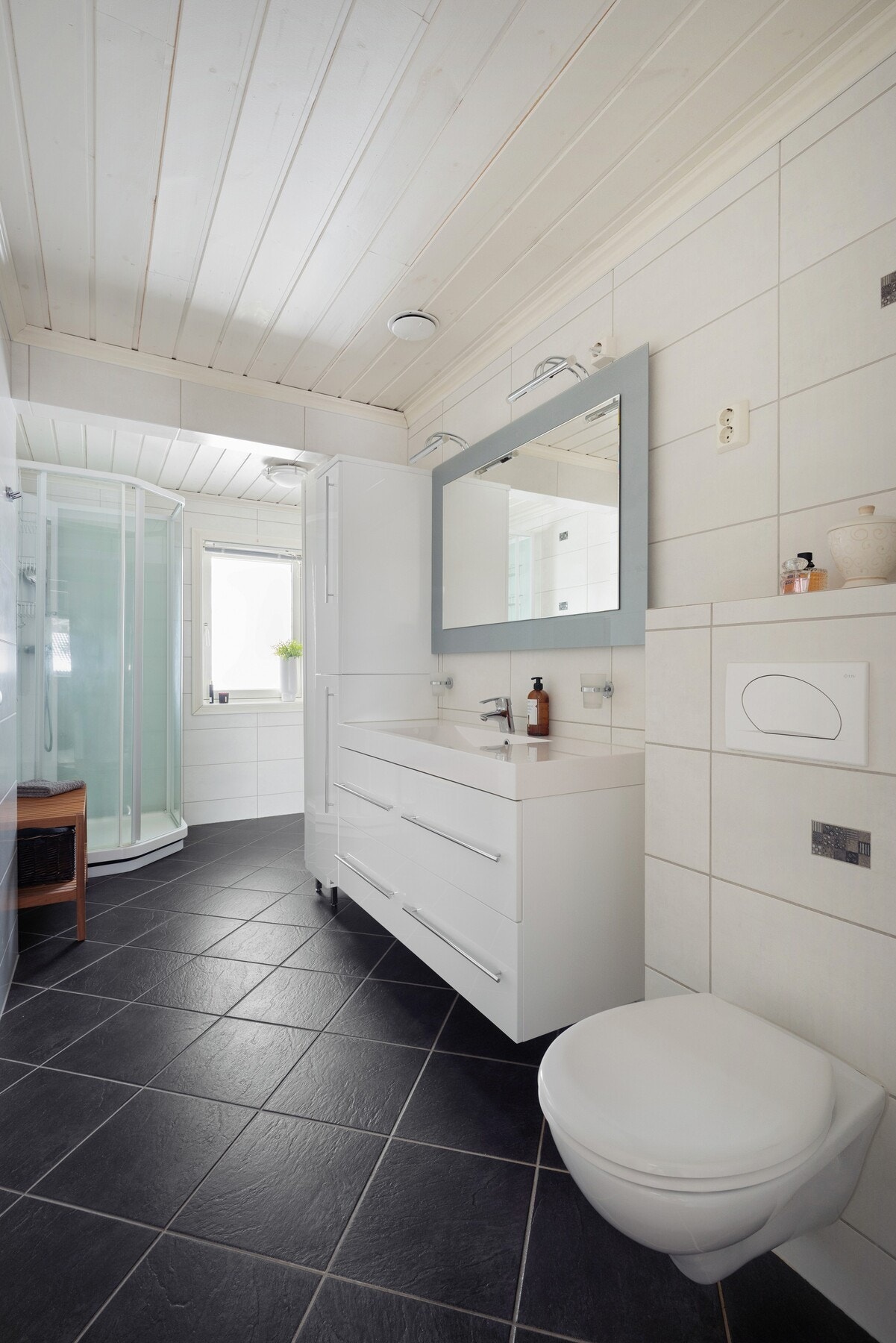 Pent og romslig bad med flislagte overflater på gulv og vegger. Galleribilde