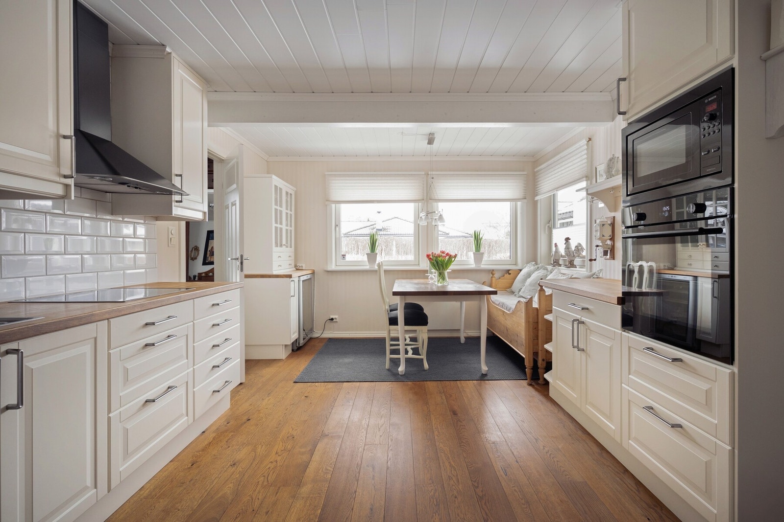 Den store spiseplassen ved vinduene skaper en hyggelig og sosial kjøkkensone med flott lysinnslipp, og gir god plass til både hverdagsmåltider og lengre middager med familie og venner. Galleribilde