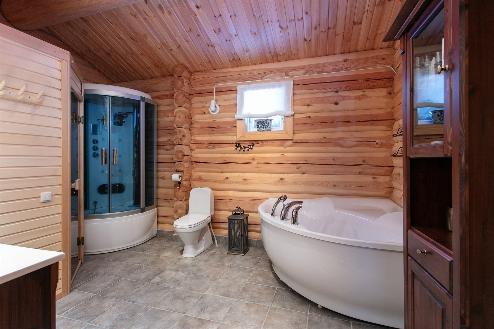 Romsmlig bad med flislagt med elektriske varmekabler, vegger i panel/tømmer og panel i tak Galleribilde