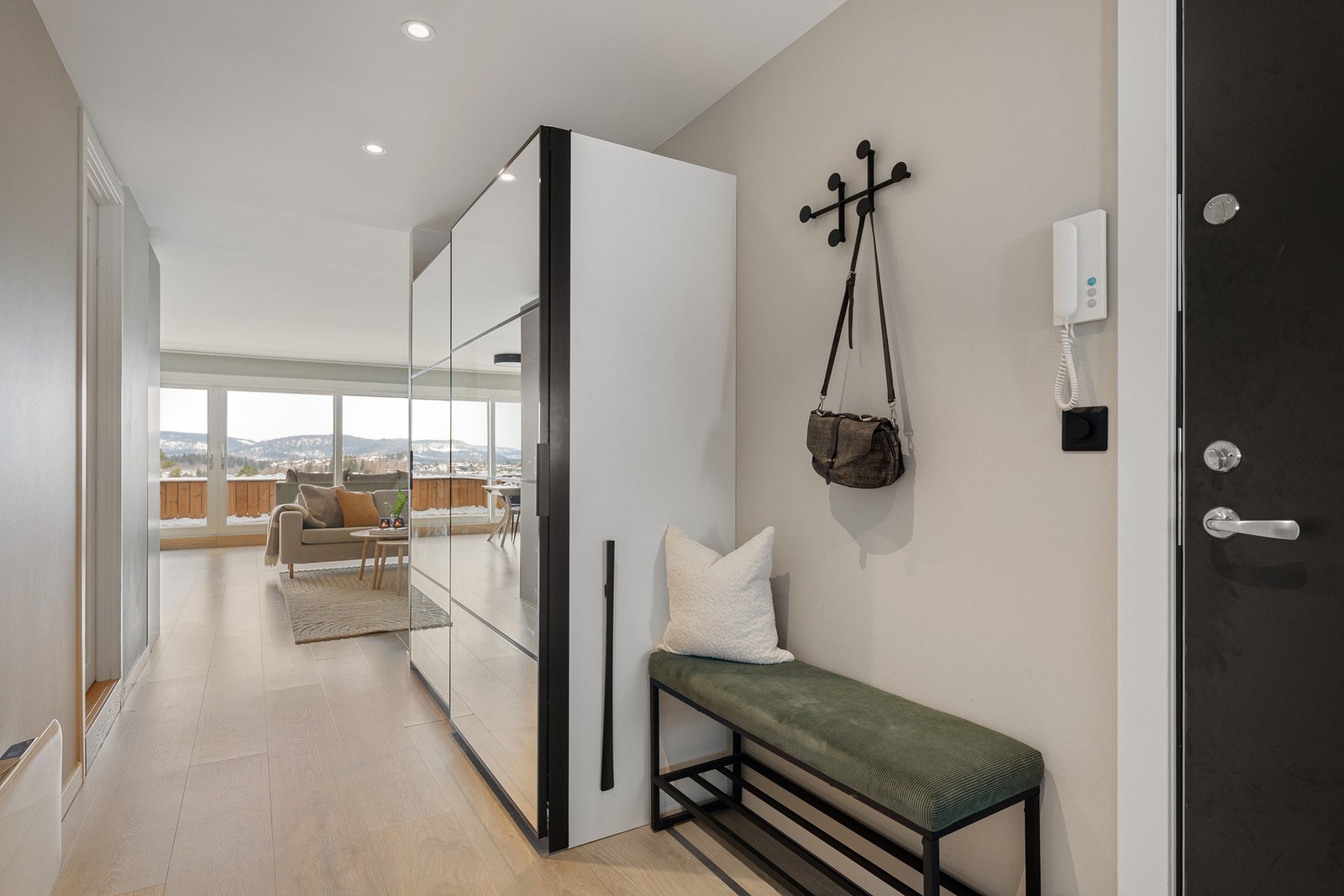 Lys og innbydende entré som fungerer som et naturlig knutepunkt i boligen. Her er det etablert romslig skyvedørsgarderobe med gode oppbevaringsløsninger og speilfronter. Galleribilde