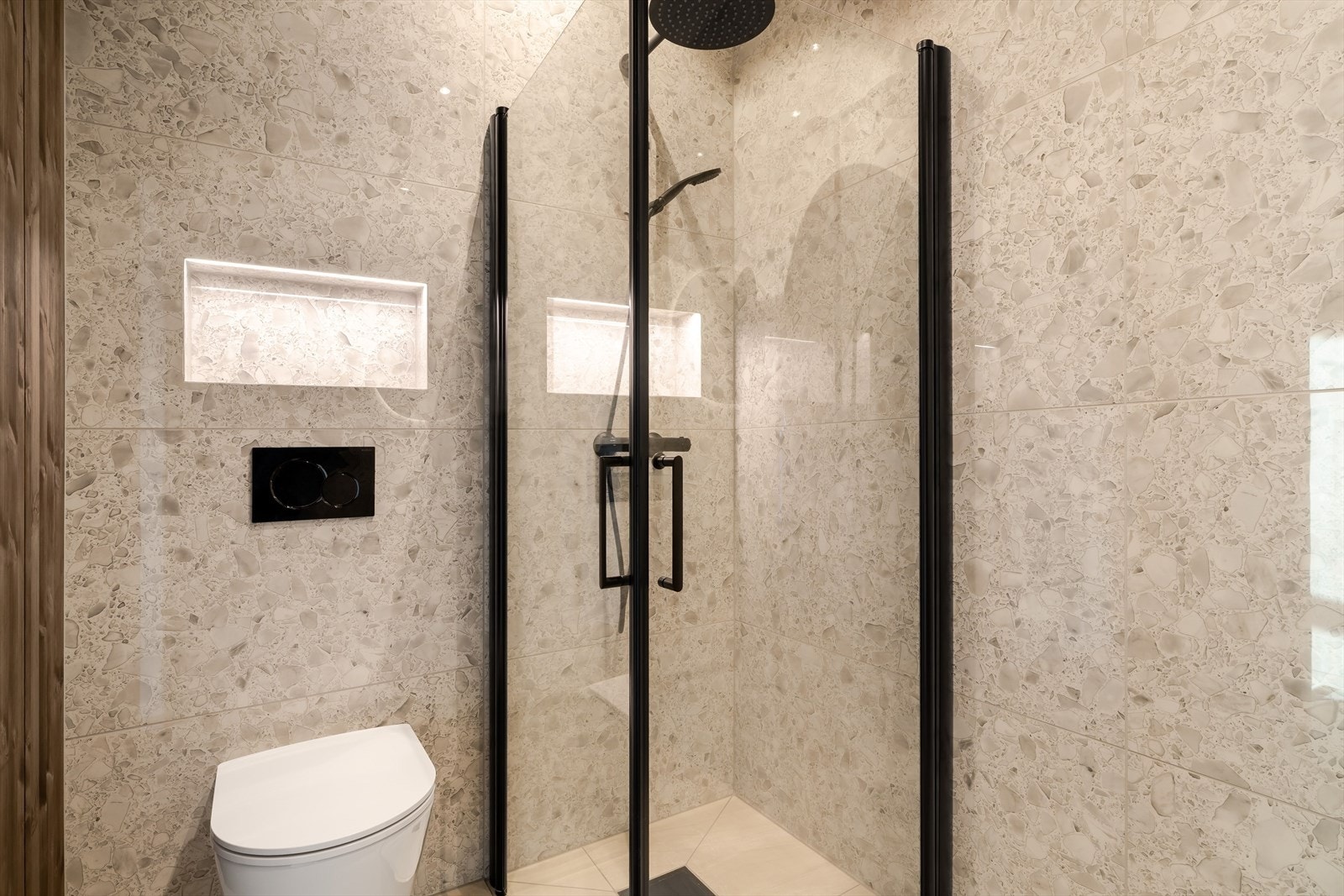 Gjennomført bad med flotte fliser og brytning med limtre på en vegg og i tak. Galleribilde