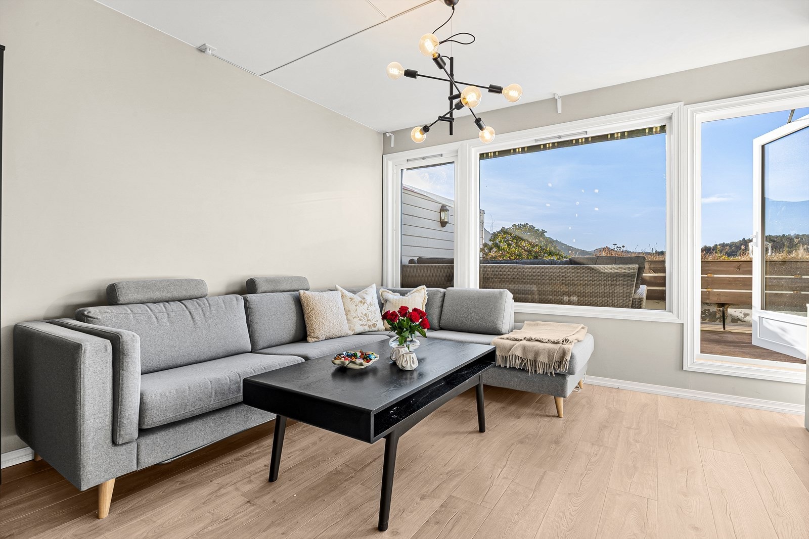 Innbydende og romslig stue med lysmalte vegger og flott laminat på gulv. Galleribilde