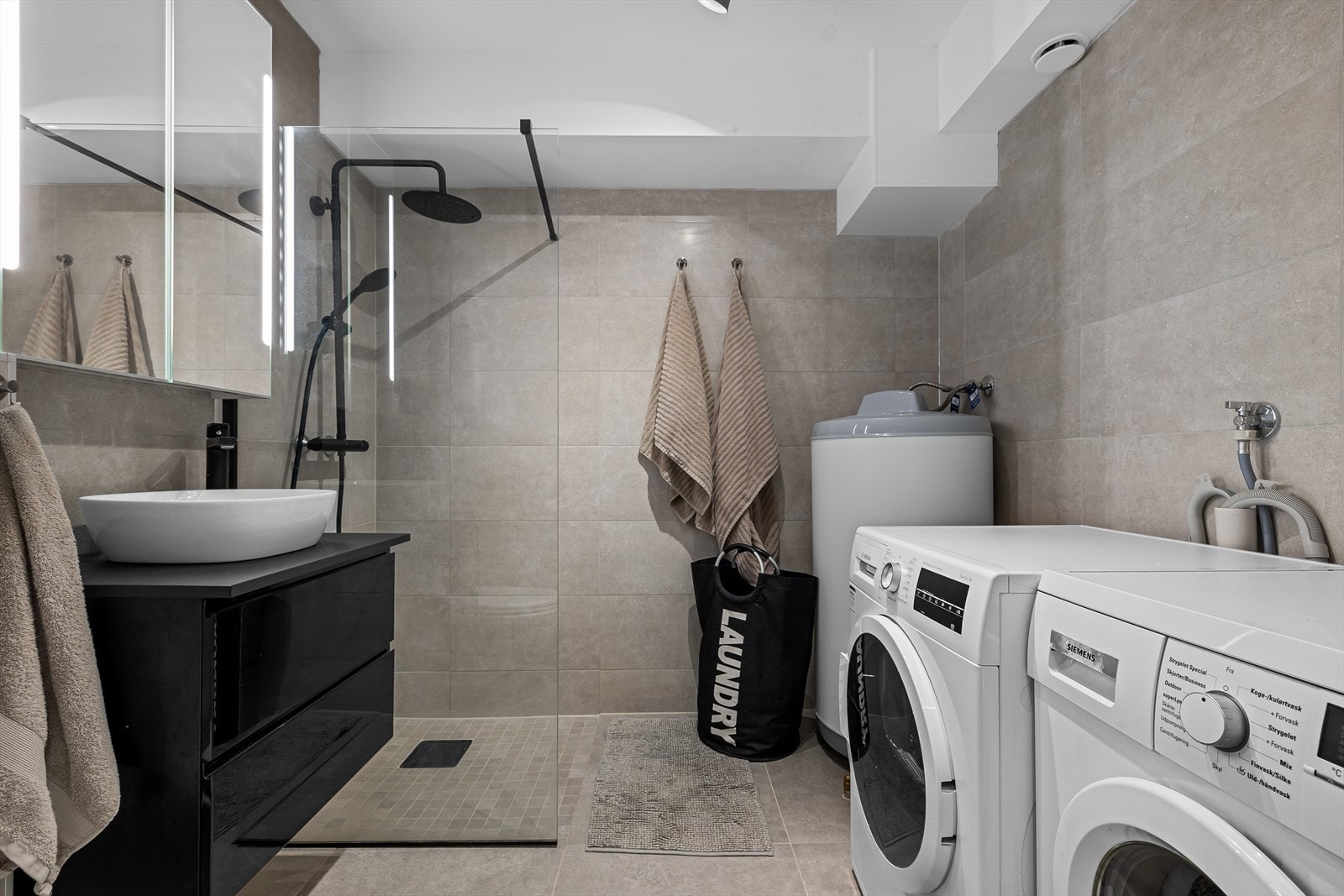 Rommet er av god størrelse og er innredet med dusj, wc og lekker servant med tilhørende skuffer. Badet har opplegg for vaskemaskin. Galleribilde