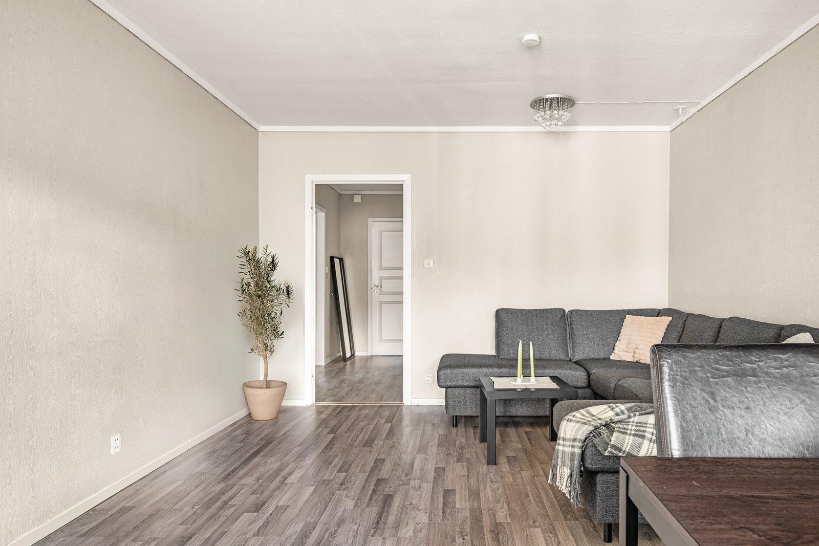 Rommet har en praktisk utforming som gjør det enkelt å møblere med en romslig sofa, mediemøblement og en hyggelig spisegruppe. Galleribilde