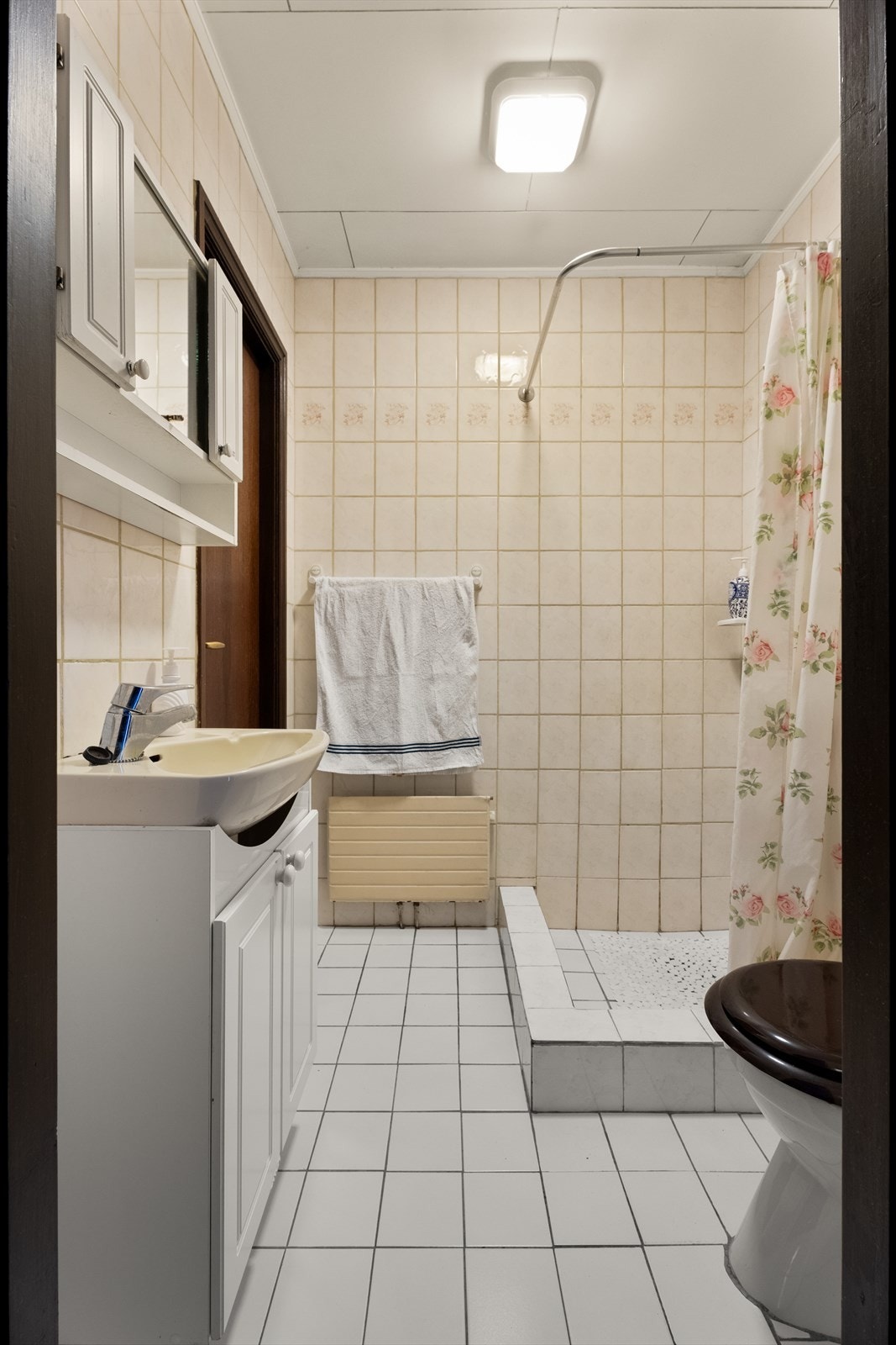 Det andre baderommet er også fra byggeår, og er utstyrt med servantskap, dusjhjørne med forheng og wc på sokkel. Galleribilde