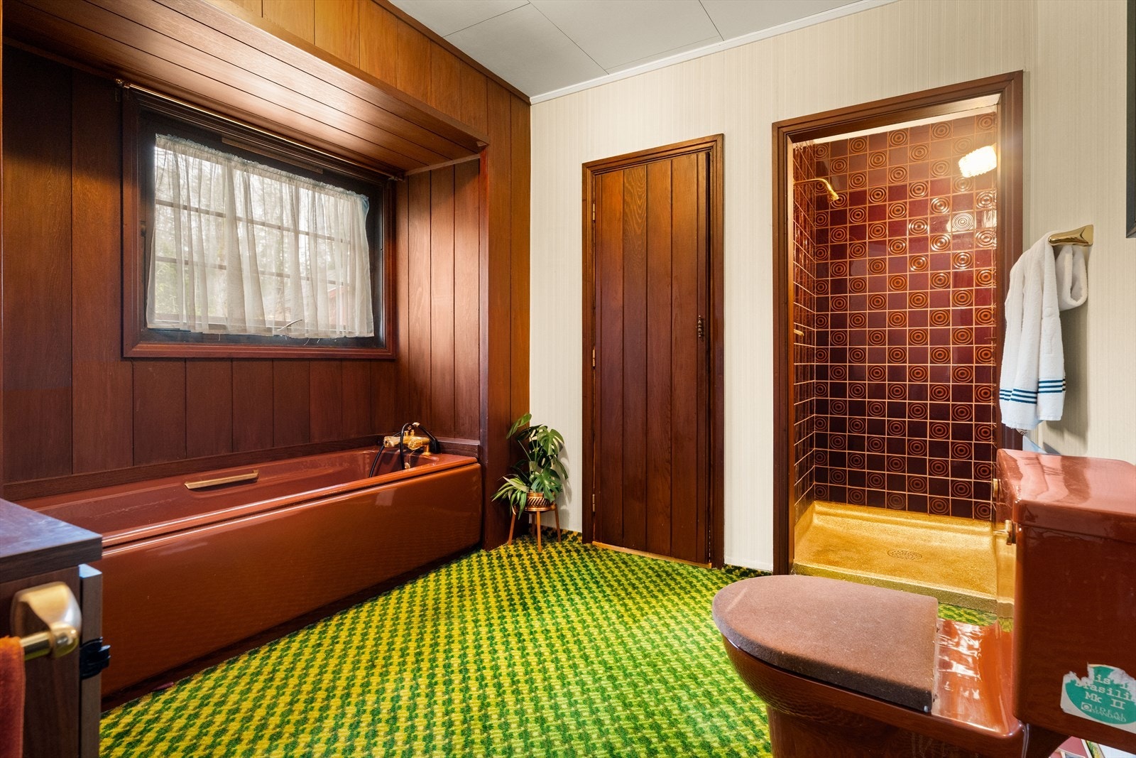 Det ene badet er fra byggeår og er utstyrt med servantinnredning, badekar, dusjnisje med forheng og WC på sokkel. Galleribilde