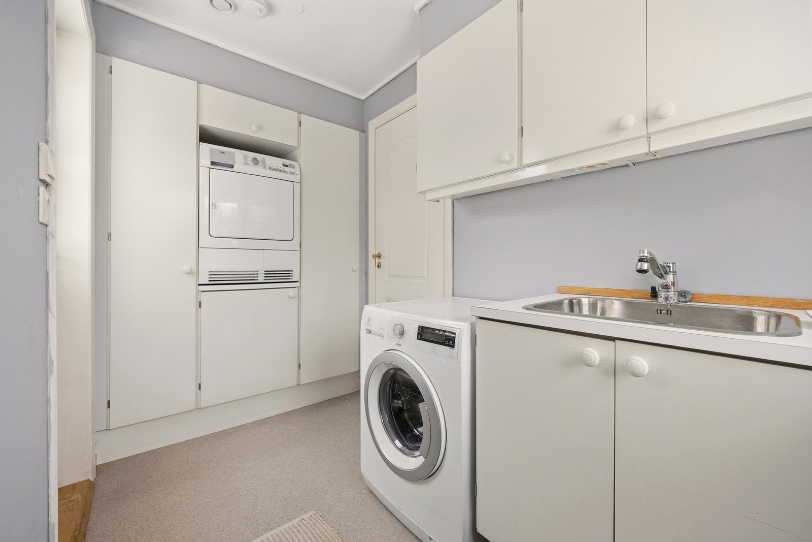 Grovkjøkkenet har plass til vaskemaskin og tørketrommel, og har egen utgang til hagen. Galleribilde