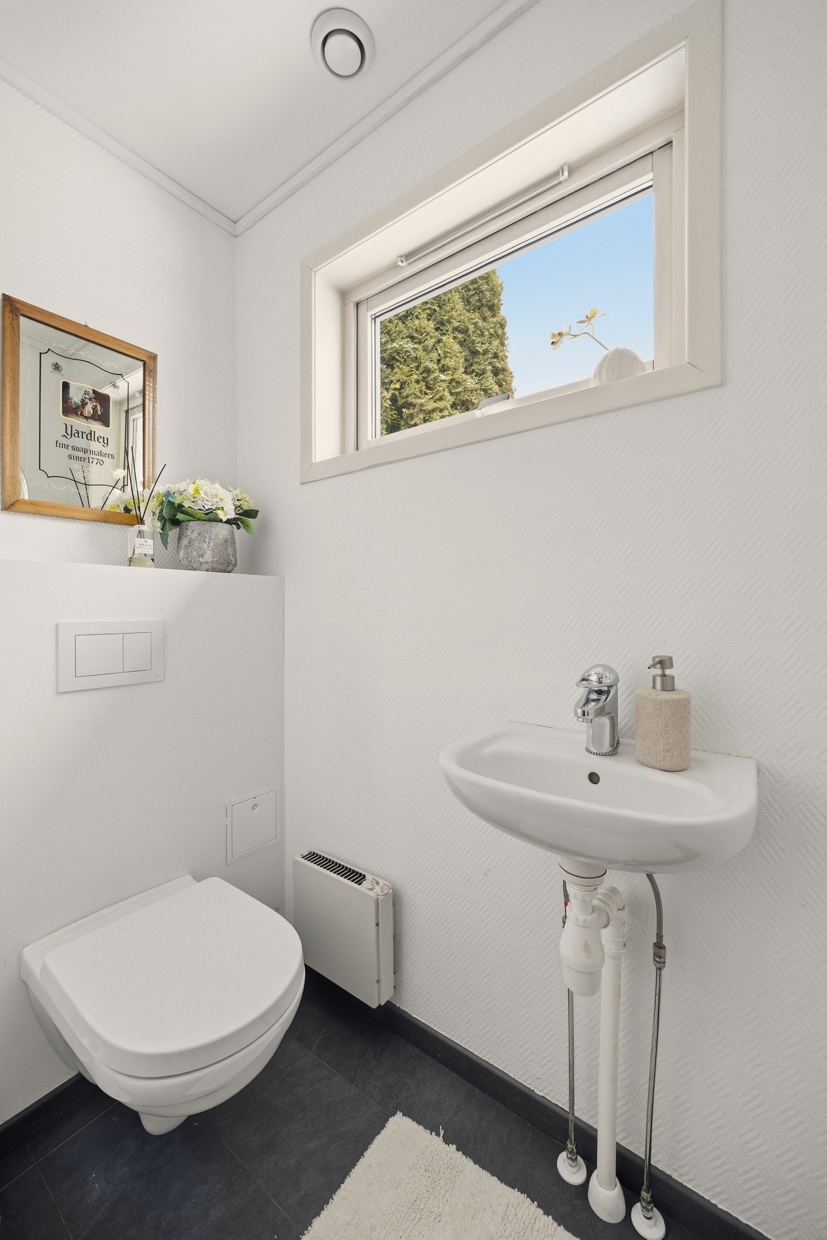 Toalettrommet i1.etasje har servant med ett-greps armatur og vegghengt toalett Galleribilde