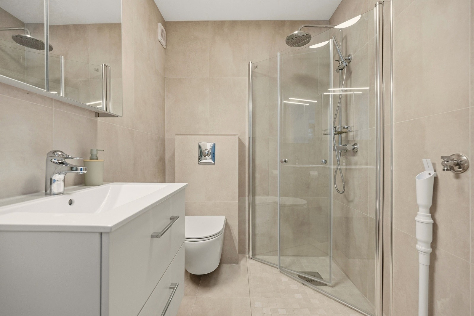 Badet i hybelleiligheten i underetasjen er totalt oppgradert i 2025 med nye varmekabler, fliser og innredning - her er det opplegg for vaskemaskin Galleribilde