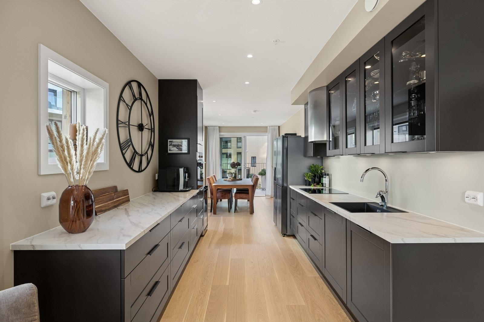 Kjøkkenet har en moderne og delikat innredning med mørke, malte fronter og integrerte hvitevarer. Galleribilde