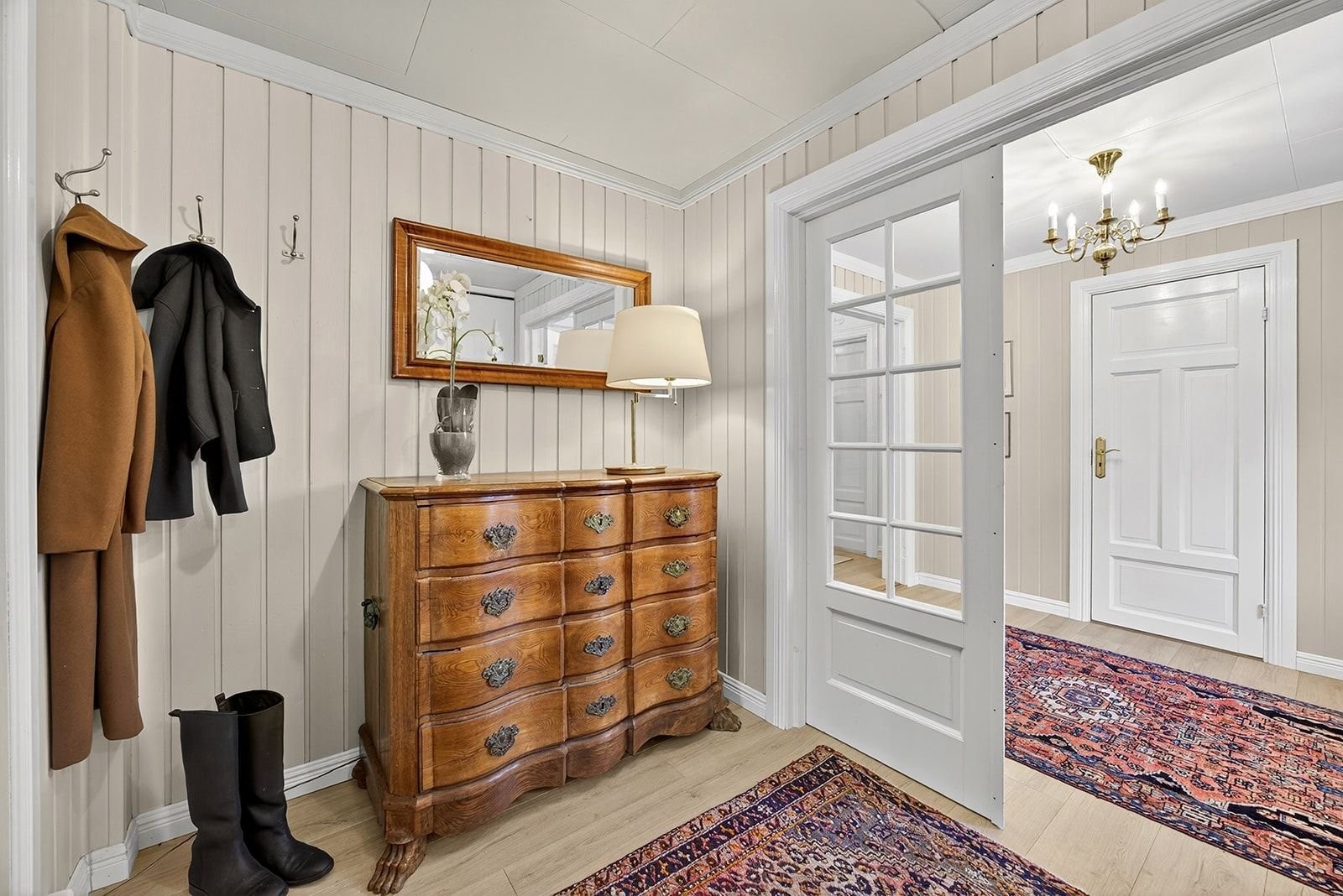 Romselig entrè med skyvedøresgarderobe og god plass til oppbevaring/sittebenk på motsatt vegg. Galleribilde