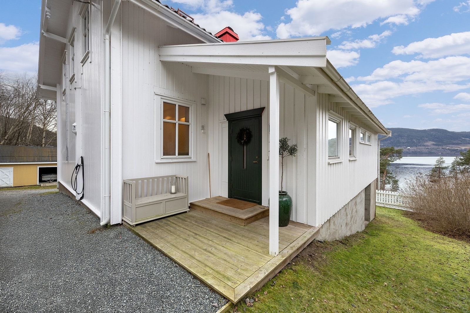 Inngangspartiet har overbygg og belysning. Det er også lys og el-billader ved biloppstillingsplassen utenfor døren. Galleribilde