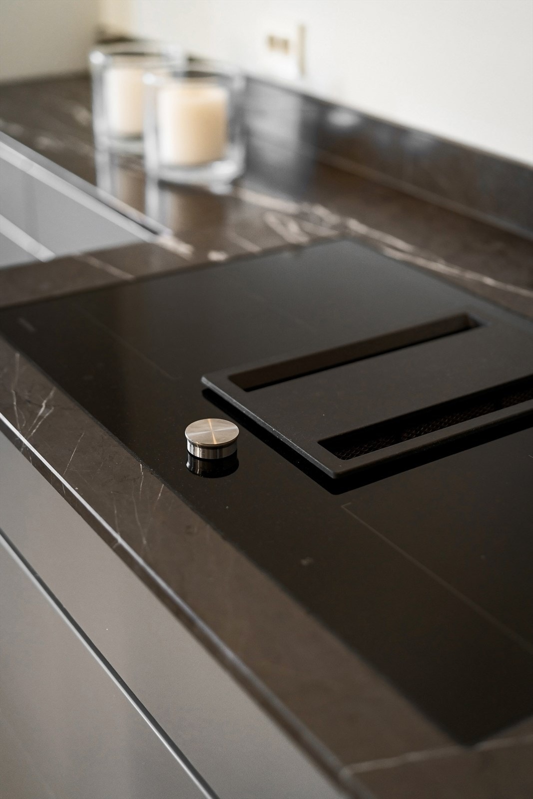 Solid mørk marmor benkeplate med platelimt koketopp og ventilator fra Gaggenau. Galleribilde