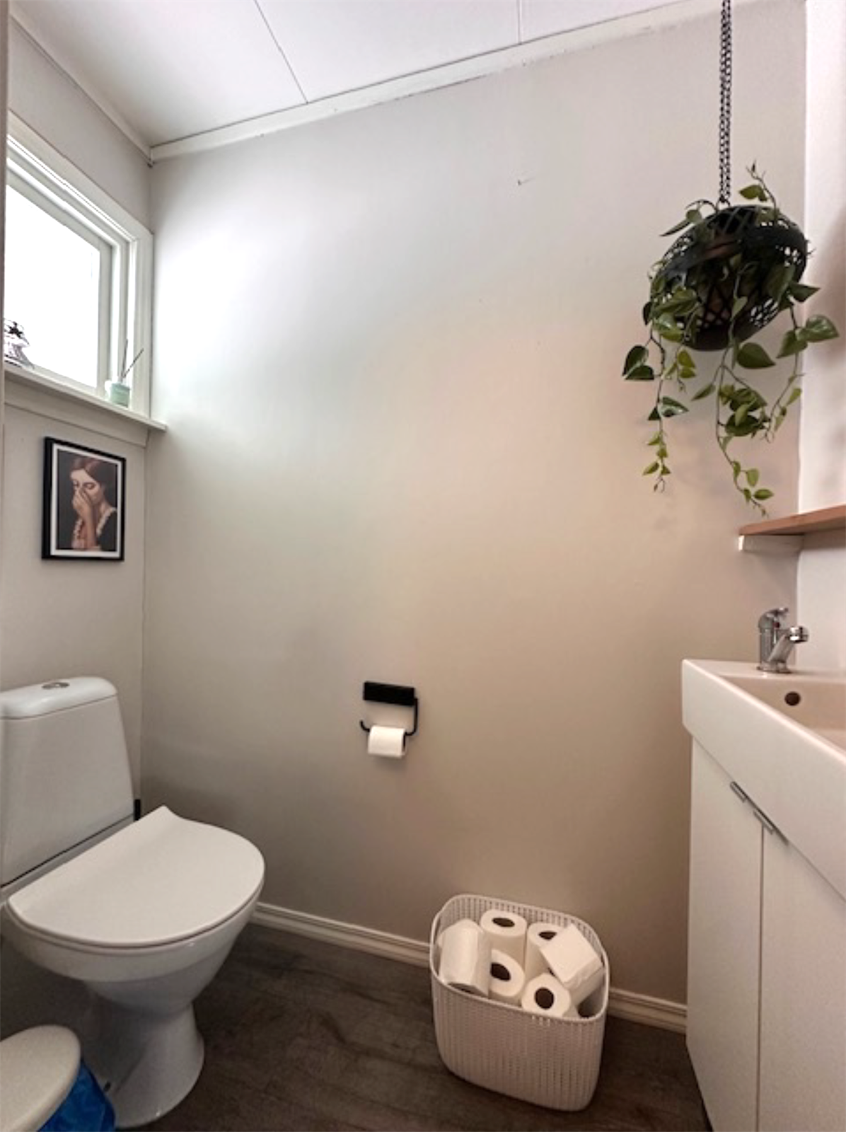 Adskilt toalettrom med gulvstående toalett og servant i skapinnredning. Galleribilde