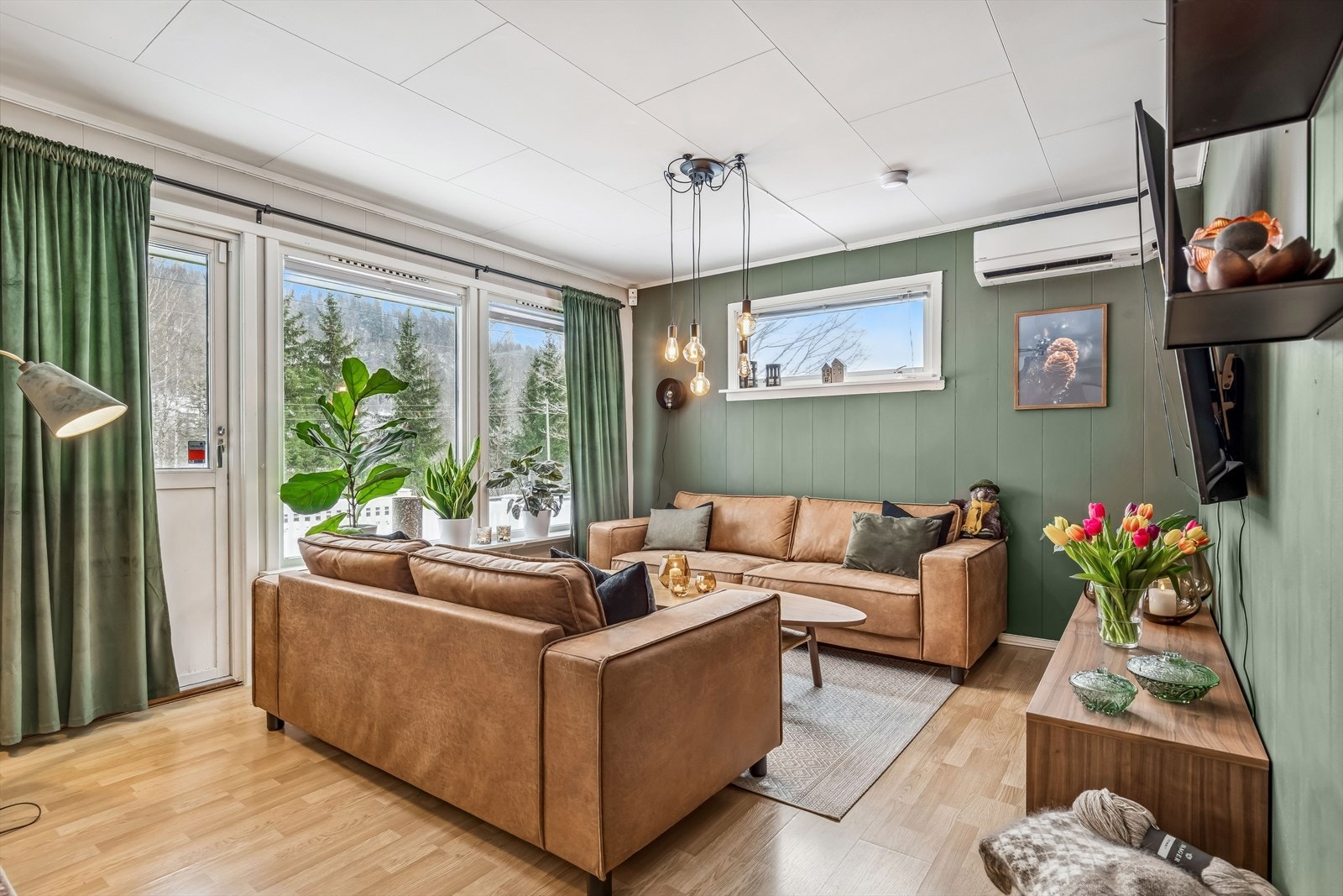 Stuen er malt med en behagelig grønntone, har laminatgulv og utgang til terrasse. Galleribilde