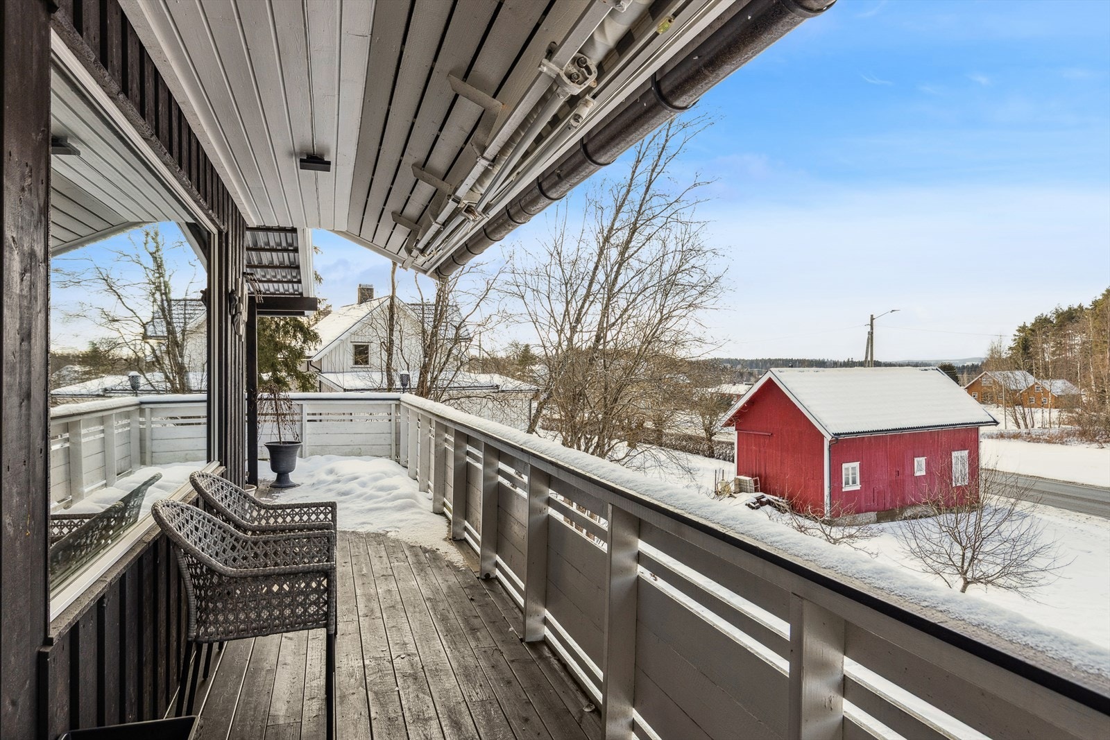 Stor terrasse som strekker seg rundt huset Galleribilde