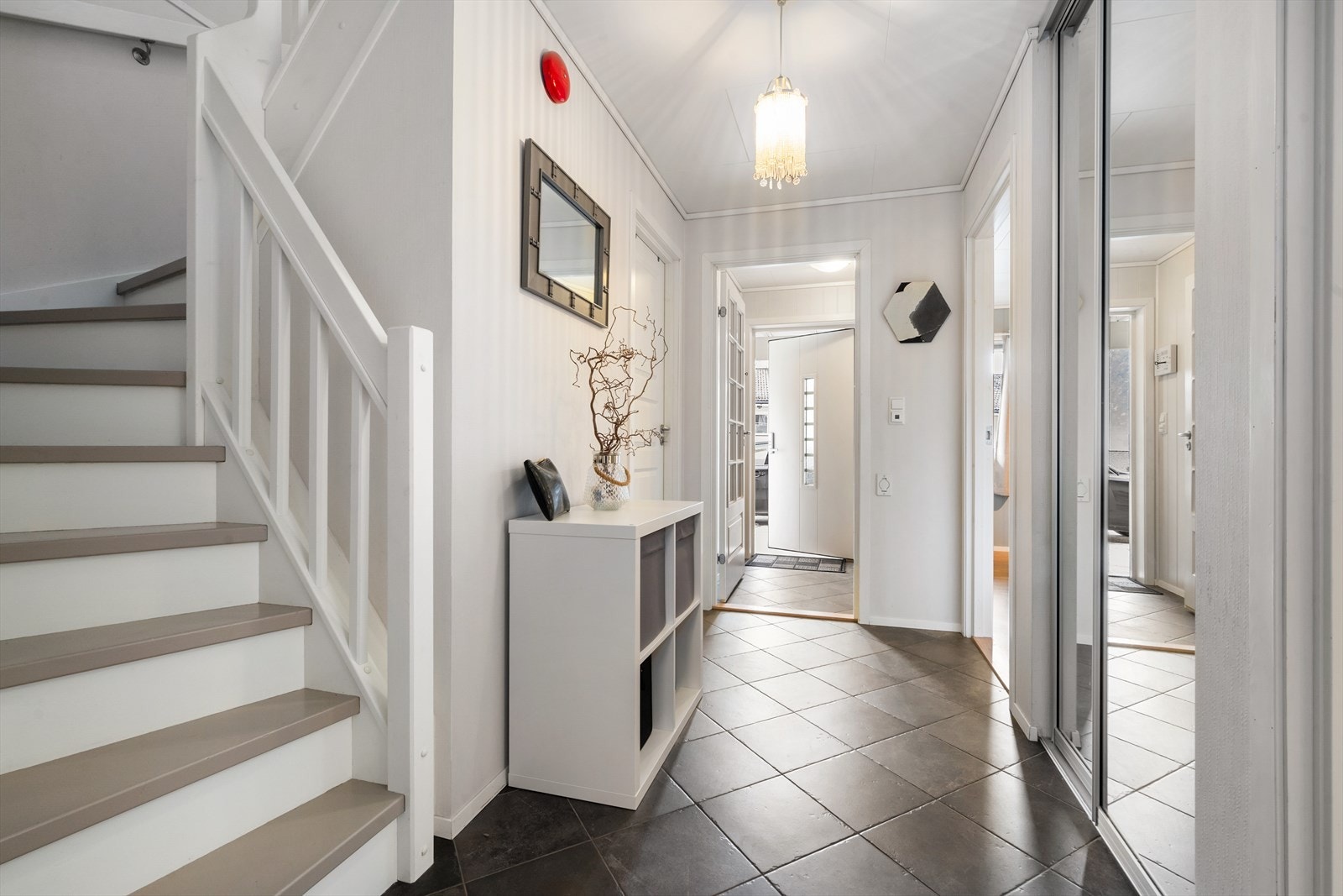 I 1.etasje er det flislagt hall med varmekablar og skyvedørsgardeorbe. Galleribilde