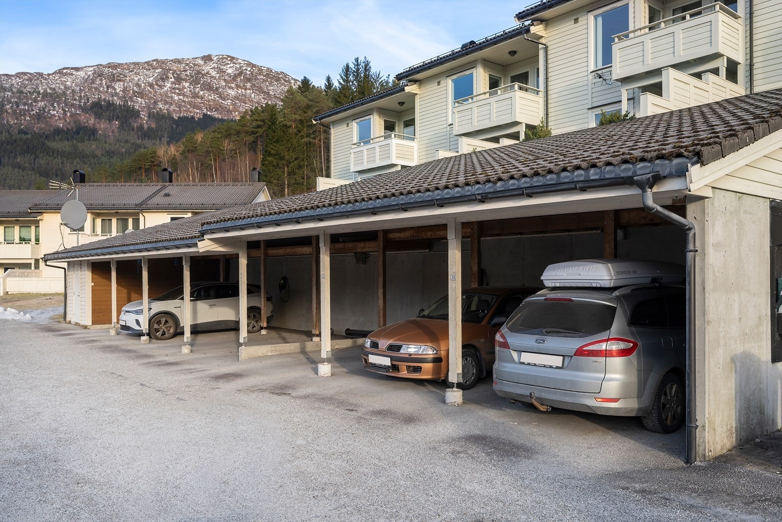 Bustaden disponerer carport nr.2 frå høgre. Det er lagt opp ekstra straum til elbilladar, men det er ikkje montert boks på veggen. Galleribilde
