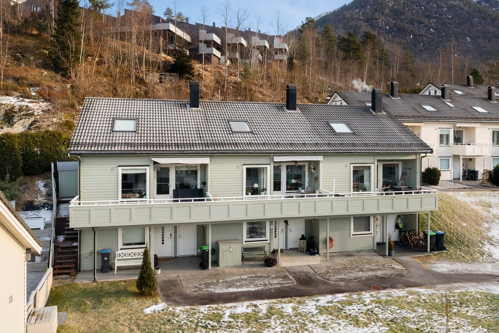 Eigedomen har flatt og lettsteld tun. Rekka er måla i lys og fin grøntone. Galleribilde