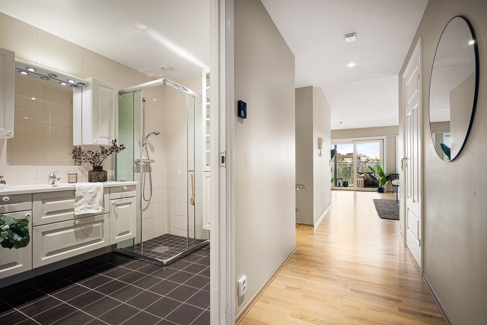 Hovedbadet med tilgang fra gangen er romslig og praktisk, og er utstyrt med dusj, god oppbevaringsplass, vask, vegghengt toalett, samt opplegg for både vaskemaskin og tørketrommel. Galleribilde