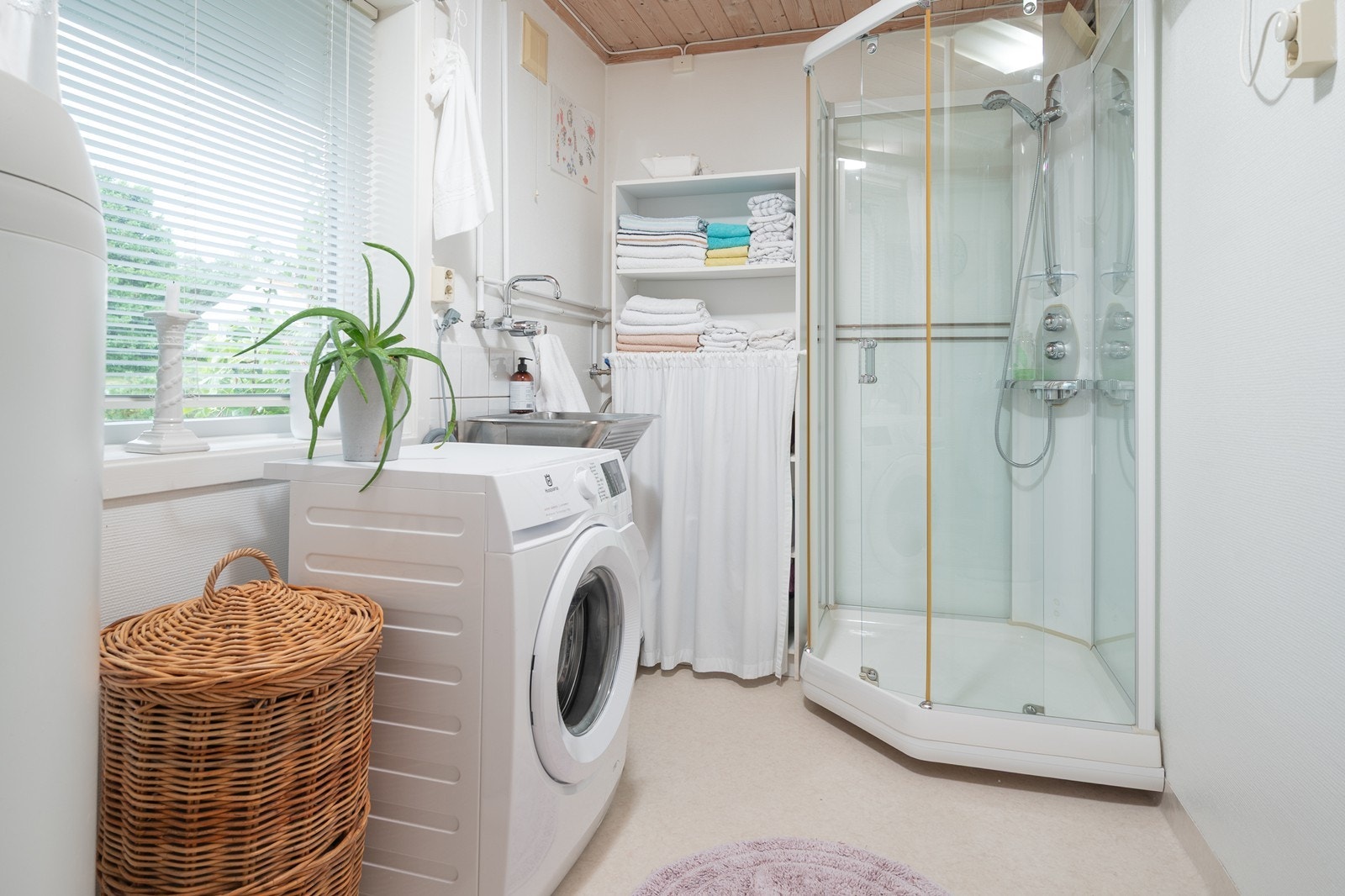 Praktisk vaskerom med dusjkabinett, opplegg til vaskemaskin og diverse hyller ut utslagsvask/skyllekum. Galleribilde