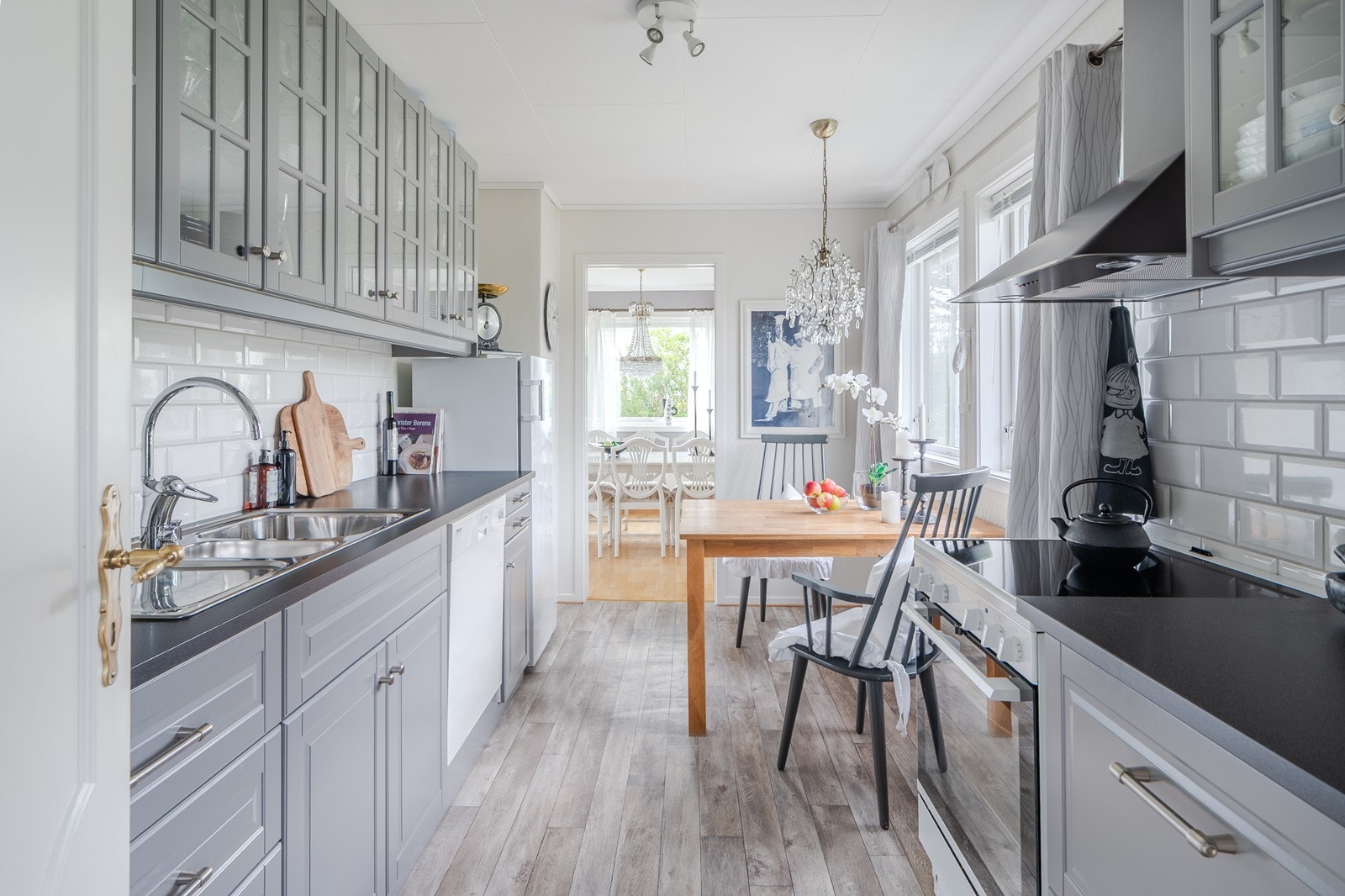 Kjøkkenet har grå fronter og fliser mellom benk og overskap, med kjøkkeninnredning fra ca. 2015. Plass til spisebord. Galleribilde