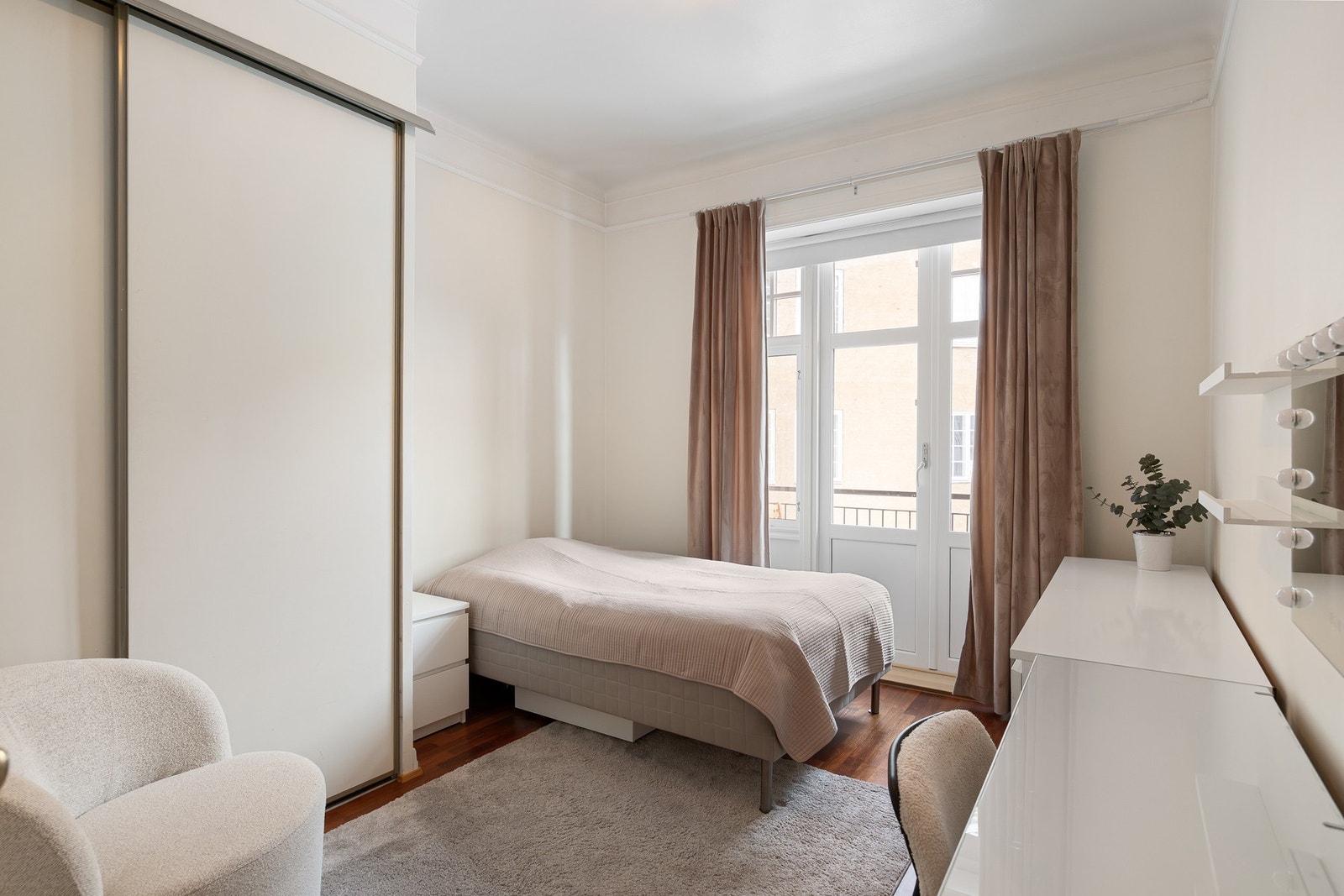 Lyst og innbydende soverom med utgang til balkong som vender mot hyggelig bakgård. Galleribilde