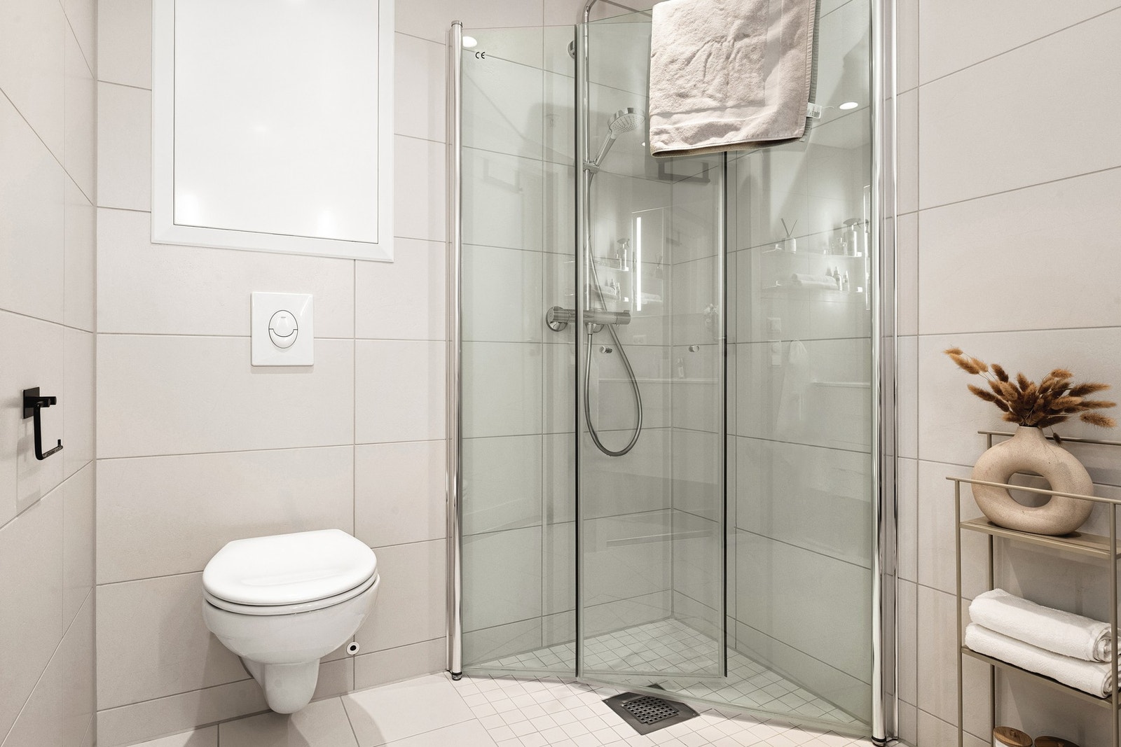 Badet har dusj med glassvegger, vegghengt toalett, baderomsinnredning og opplegg for vaskemaskin. Galleribilde