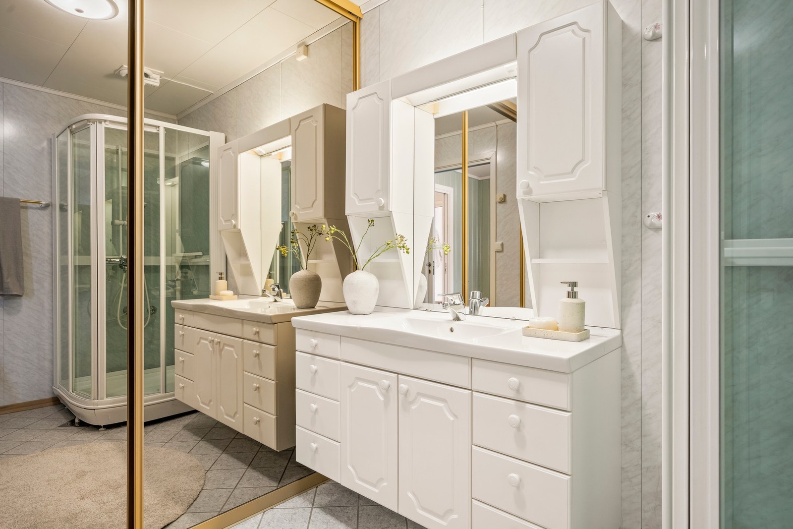 Utstyrt med dusjkabinett, servant med skap og porselensvask, overskap, speil med lys, gulvmontert wc. Galleribilde