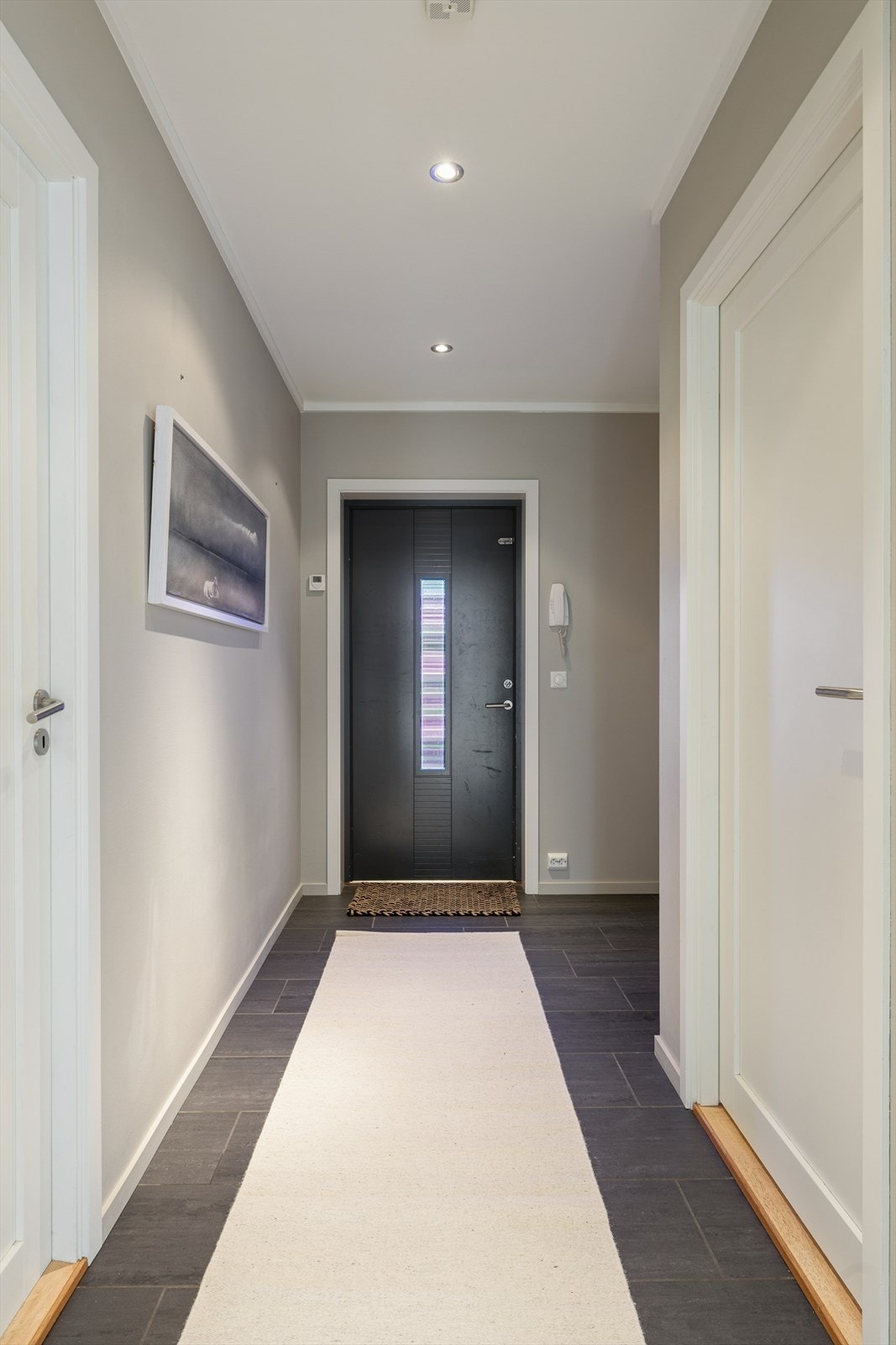 Når du kommer inn i leiligheten møtes du av en lys og innbydende entré med flislagt gulv og innfelte spotter i taket. Her er det god plass til å etablere oppheng og garderobeløsning for yttertøy. Galleribilde