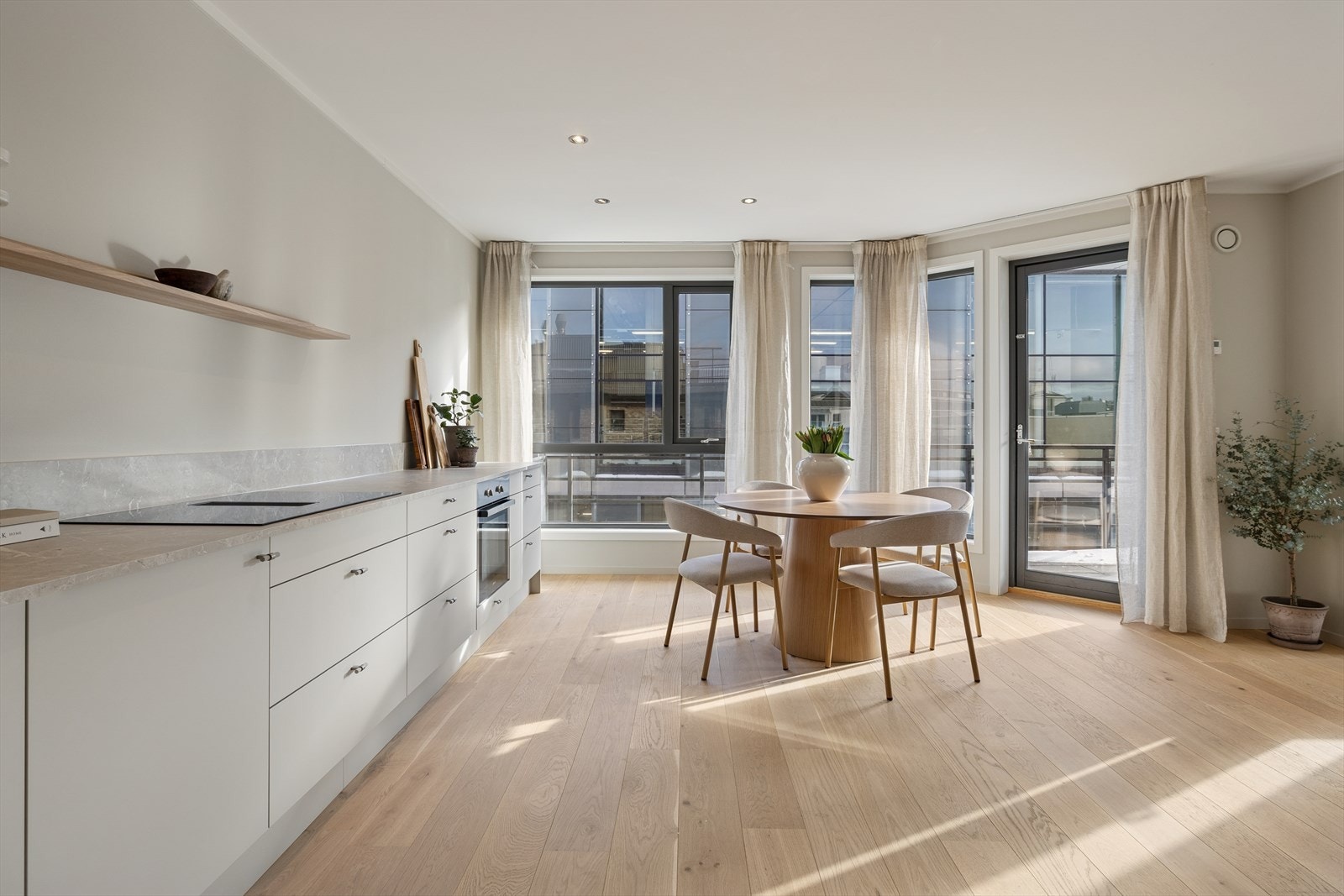 Videre inn i boligen åpner rommet seg opp mot en lys, romslig og meget trivelig stue i åpen løsning mot kjøkkenet. De store vindusflatene gir rommet et ekstra løft, og slipper inn rikelig med naturlig lys gjennom hele dagen. Galleribilde