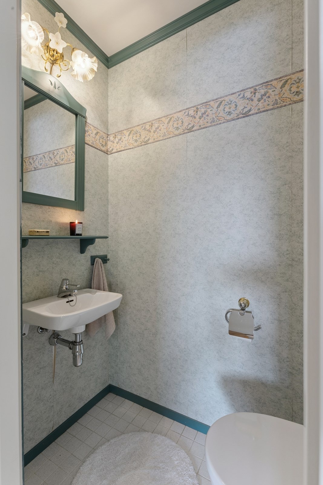 Toalettrommet er innredet med et gulvstående toalett og en enkel, vegghengt servant. Galleribilde