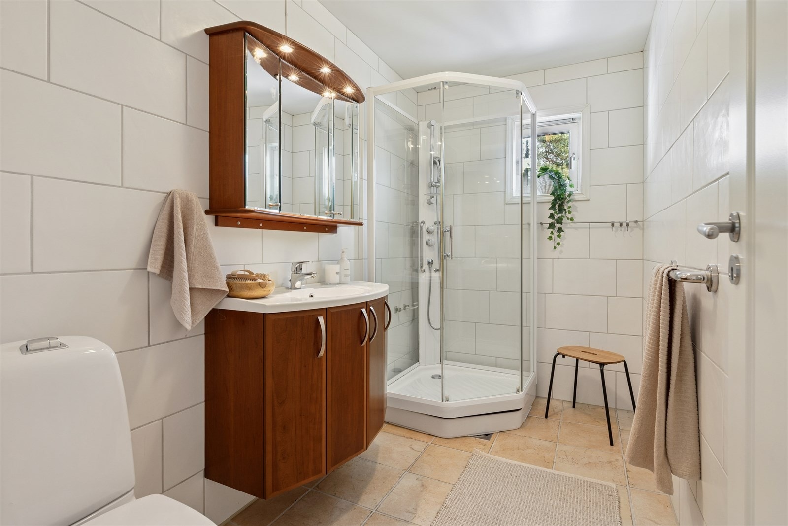 Badet er utstyrt med fliser på gulv og vegger, hvor veggene har flis på flis. Det er elektriske varmekabler i gulvet og malt himling. Galleribilde