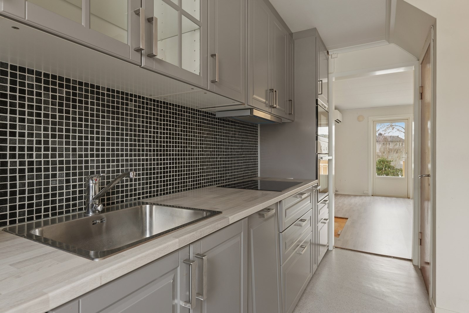 Detaljer som fliser over benkeplaten i laminat og kjøkkenventilator med avtrekk ut. Galleribilde