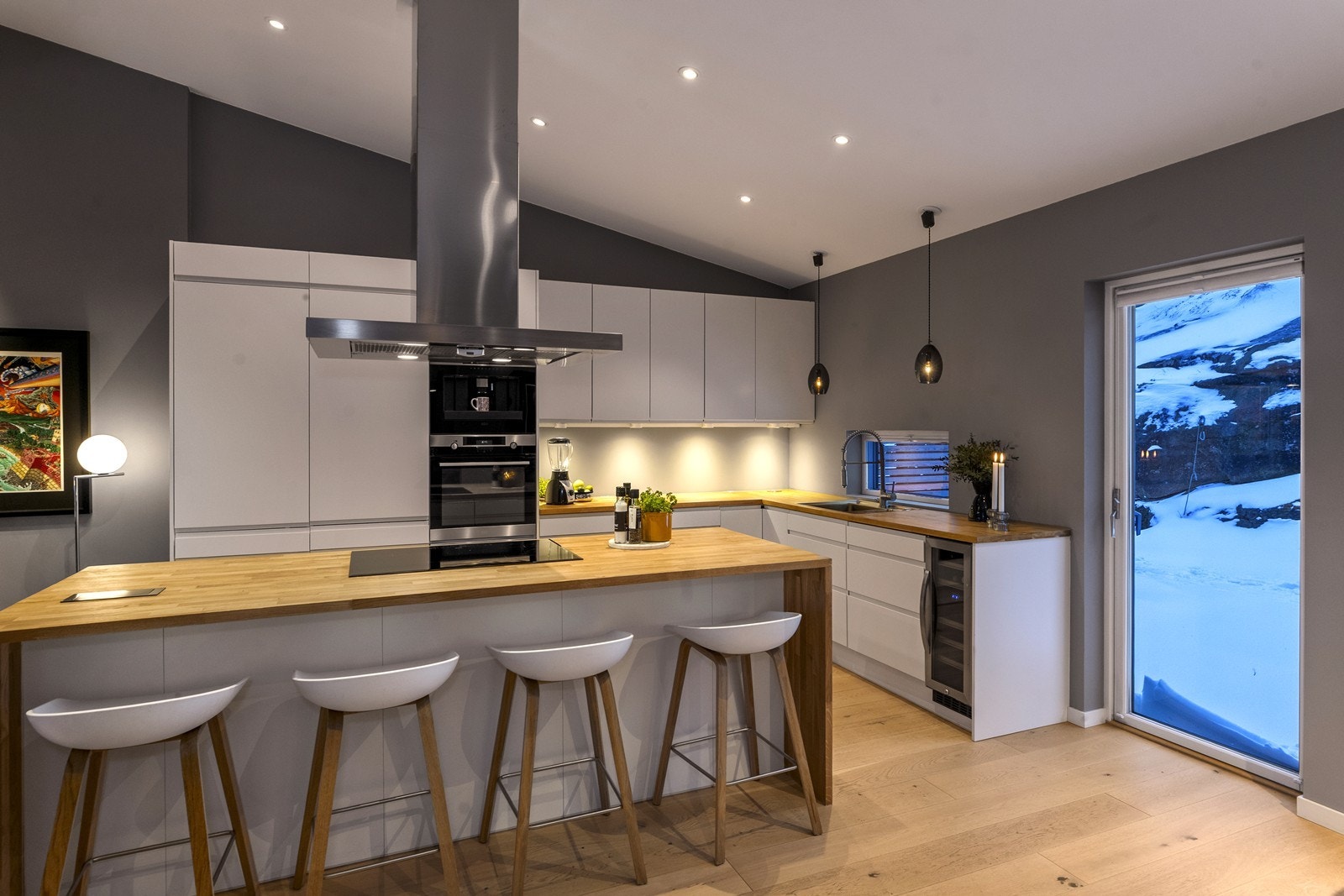 Kjøkkenet har en stor øy med heltre benkeplate og barløsning. Galleribilde