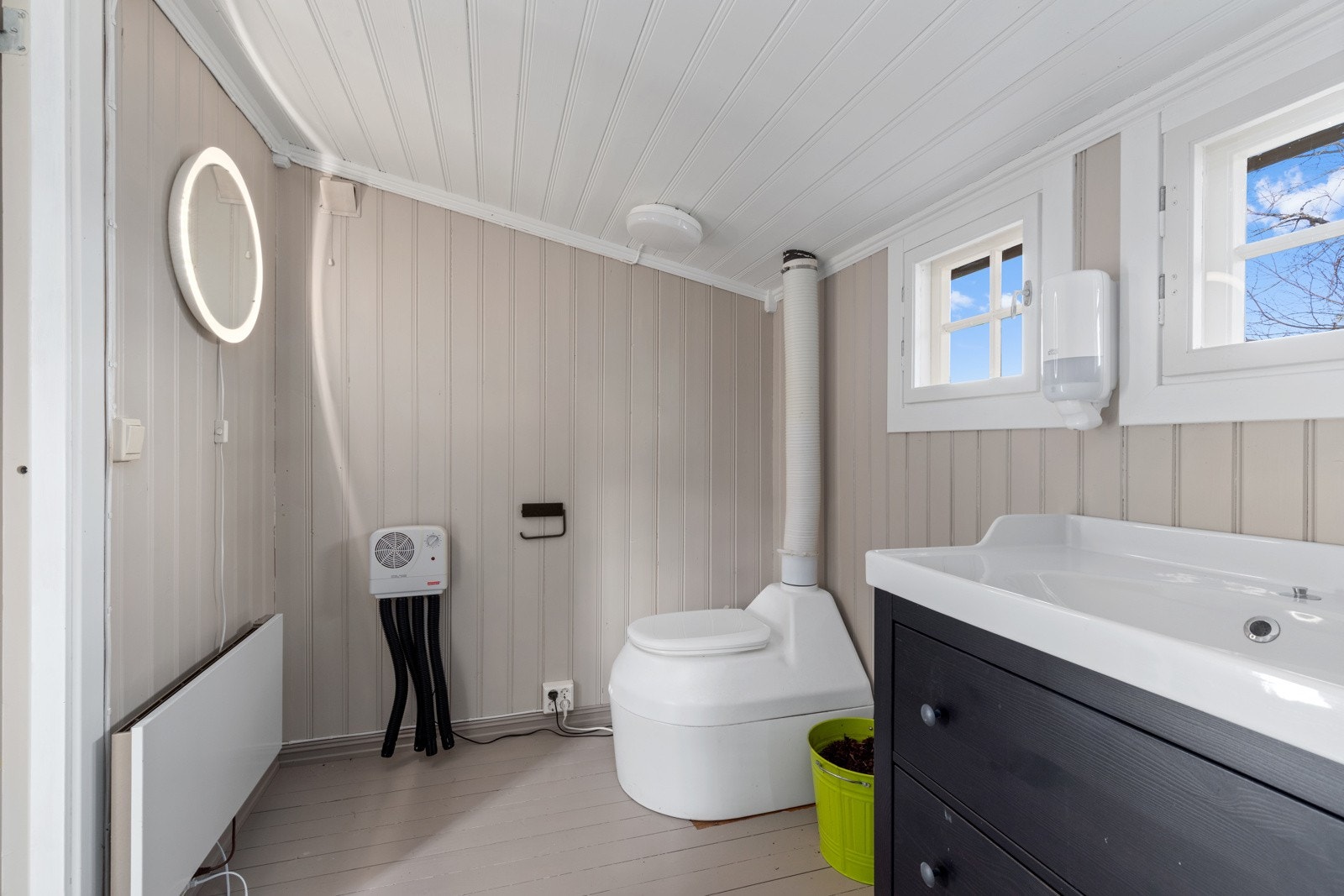 Toalettrom med montert biotoalett og skuffinnredning med avløp til terreng via gulvsluk. Galleribilde