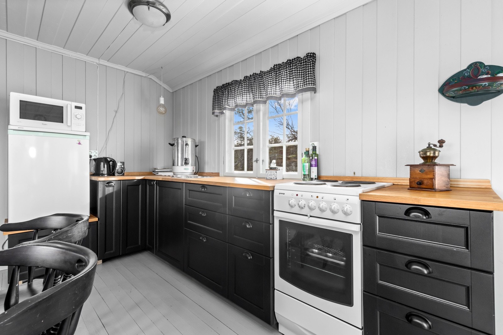 Benkeplaten på kjøkkenet består av eik. Det er også satt inn komfyr og kjøleskap. Nedfelt utslagskum, hvor gråvann går til bøtte i benkeskap. Galleribilde