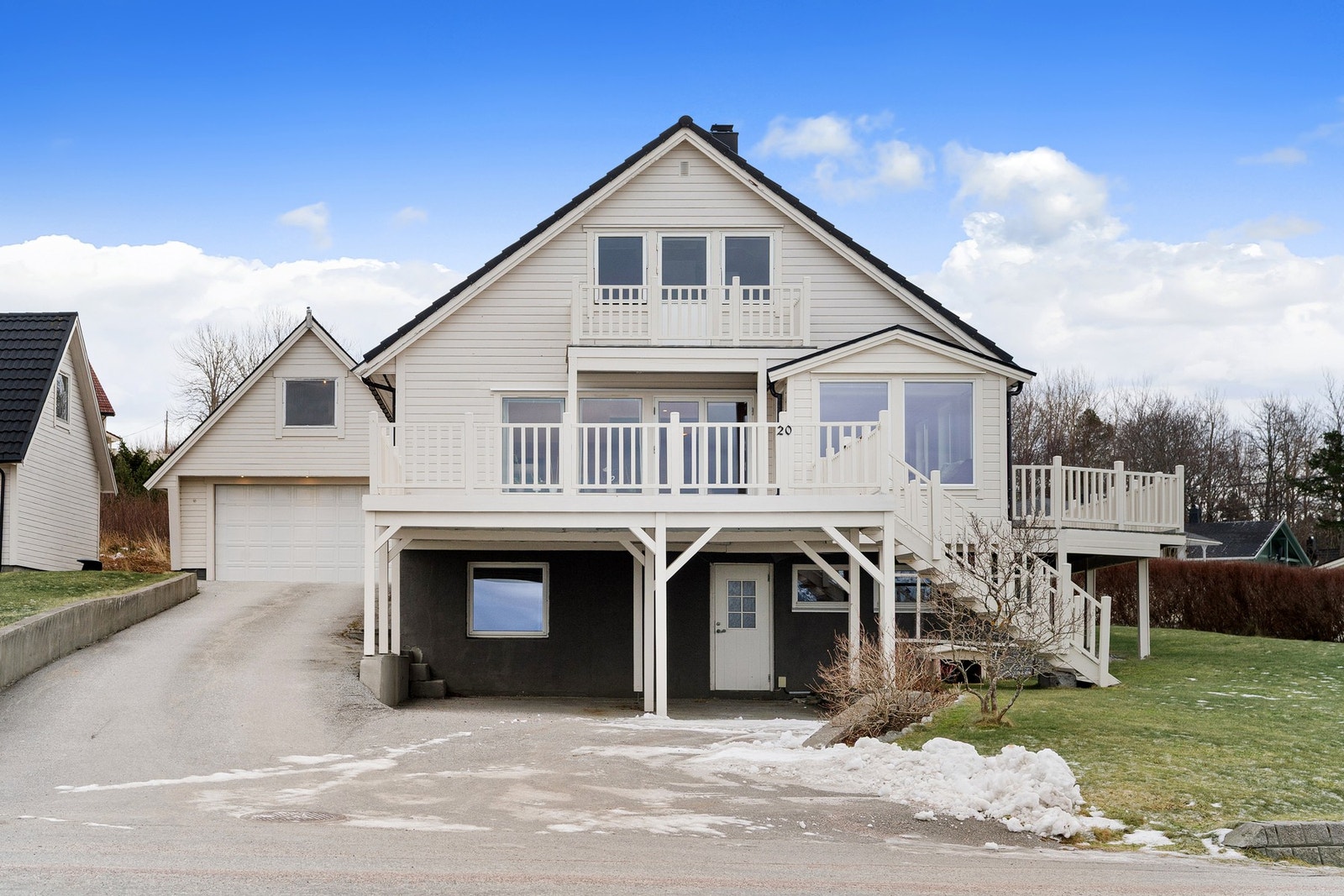 Pent uteområde med hage, veranda og asfaltert innkjørsel. Galleribilde