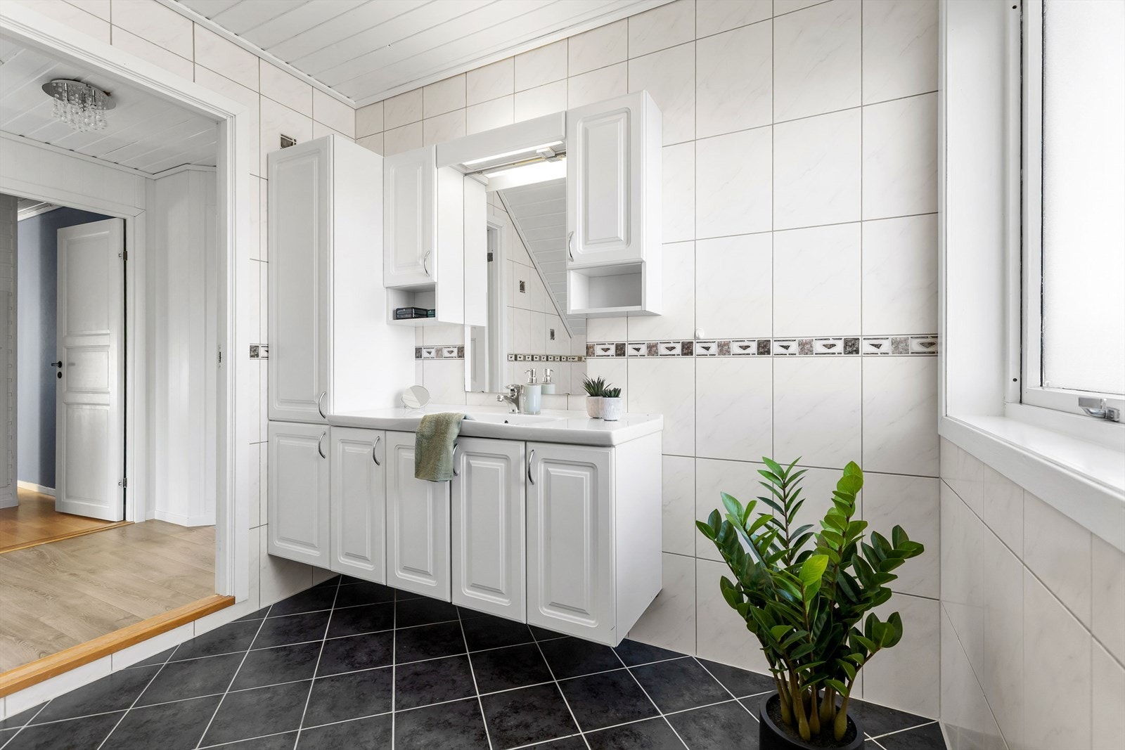 Badet har hvit tidløs innredning, hjørnebadekar og toalett. Galleribilde