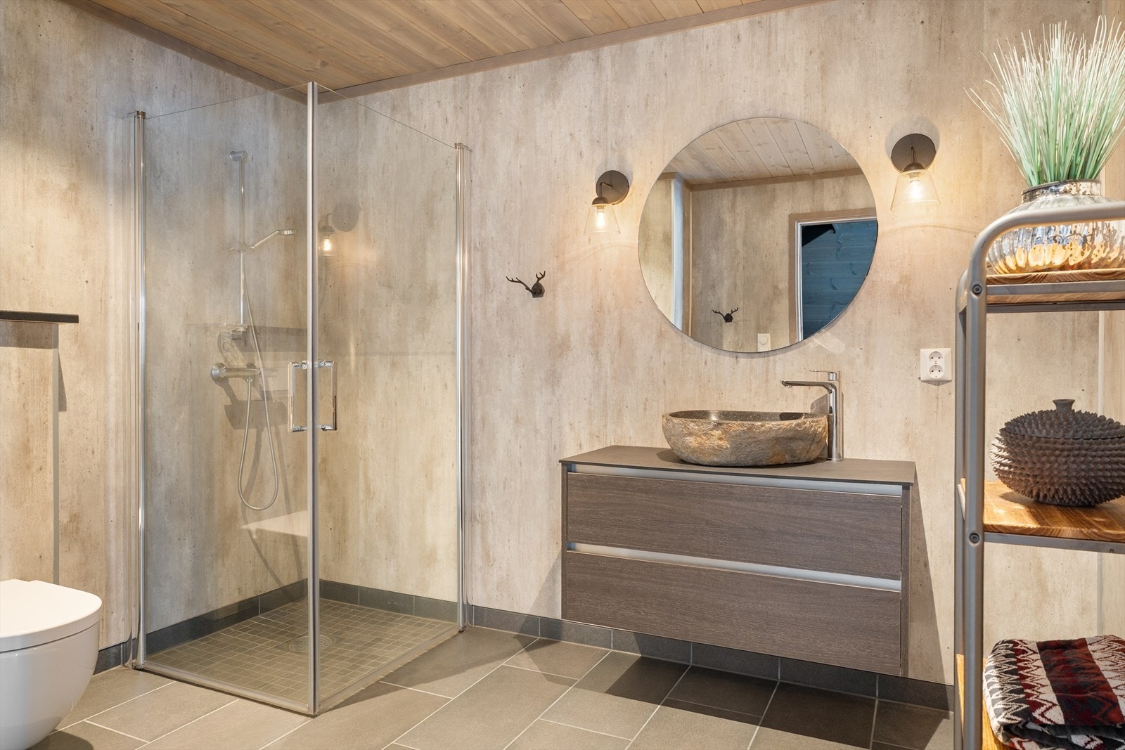 Delikat bad med med dusjhjørne, innredning med servant og vegghengt toalett. Galleribilde