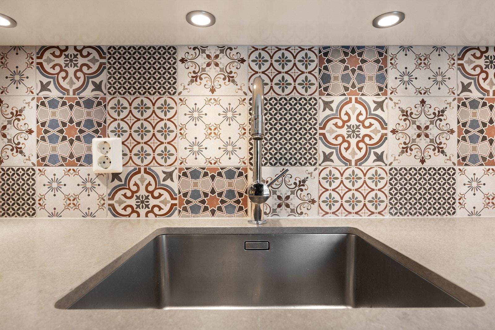 Nedsenket oppvaskkum med fliser på vegg over benkeplate. Galleribilde