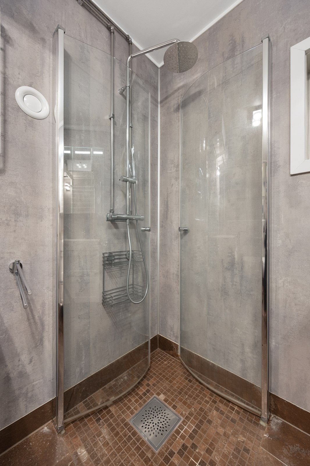 Romslig dusjhjørne med inn-/utadslående dører. Galleribilde