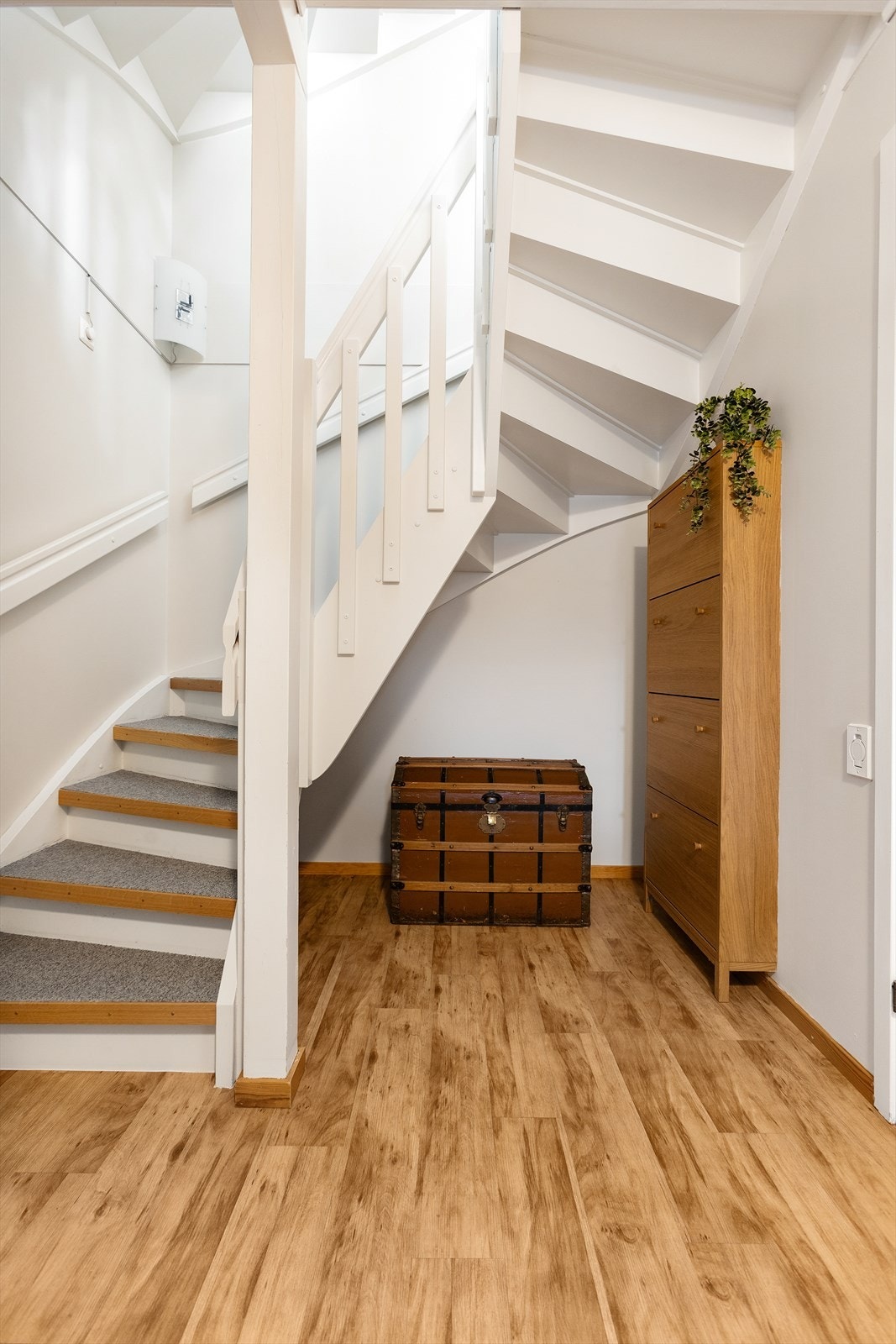 Den malte tretrappen med teppebelegg i trinnene binder etasjene sammen. Galleribilde