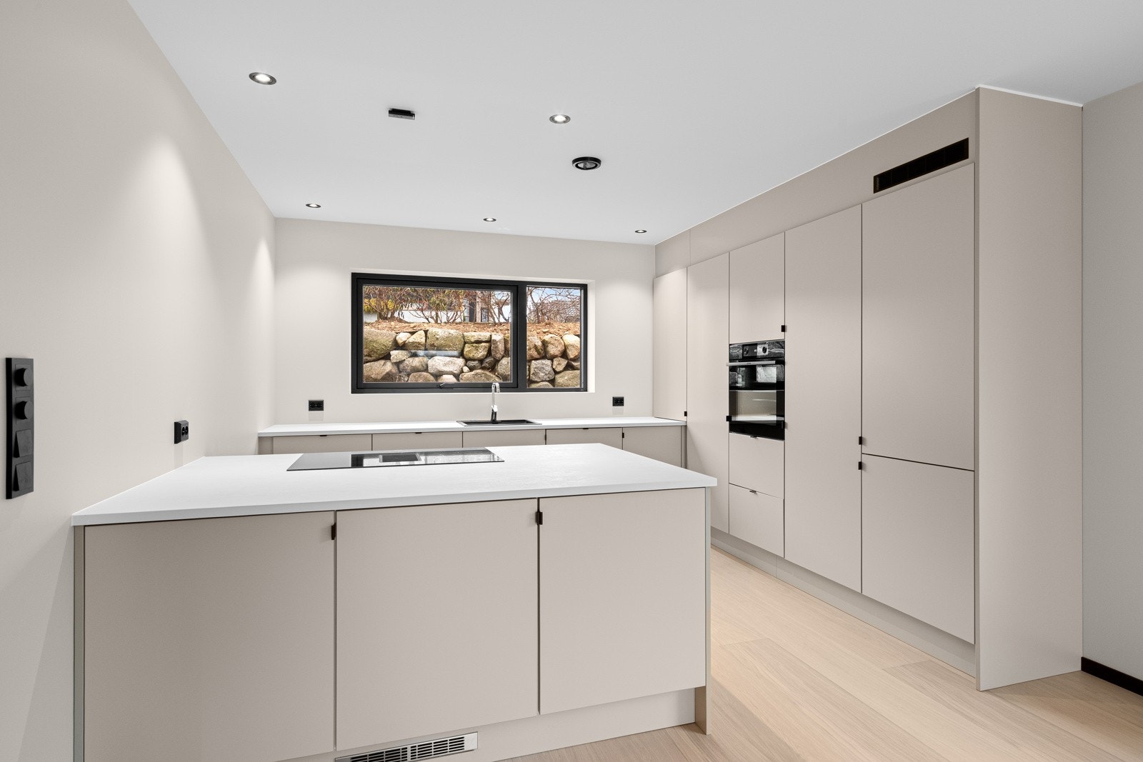 Kjøkkenet har en stilren kjøkkeninnredning levert fra Aarsland med integrerte hvitevarer som komfyr, platetopp, oppvaskmaskin og kjøleskap Galleribilde