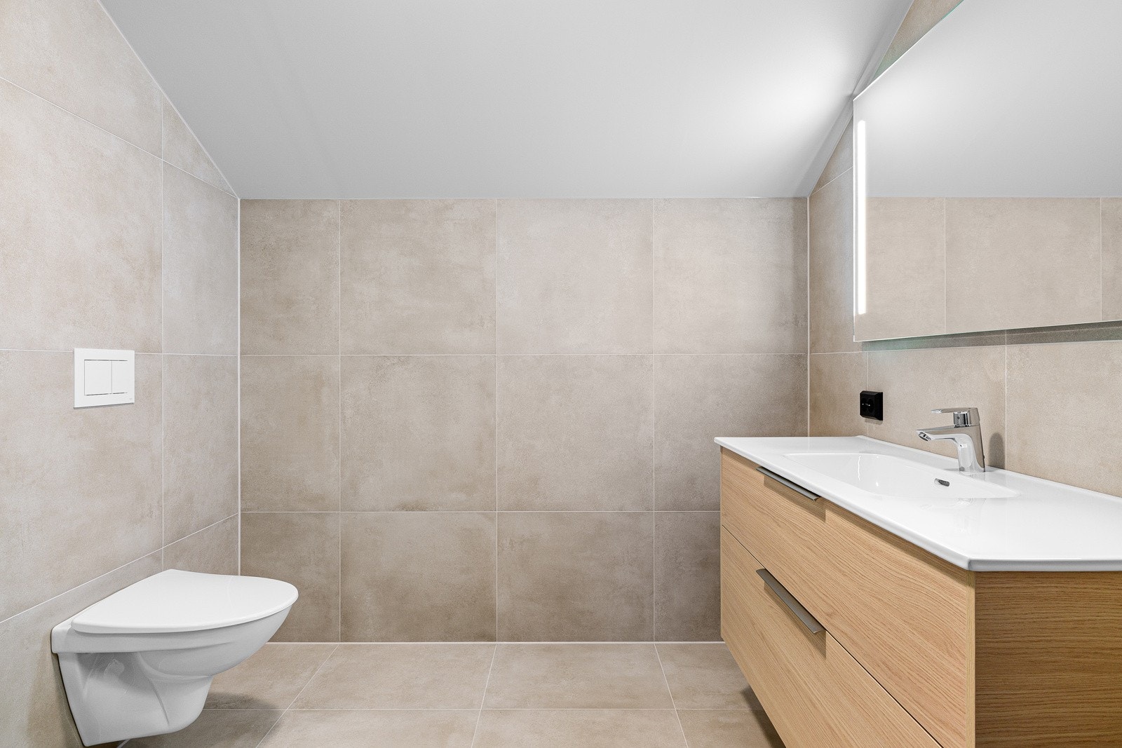 Badet i øverste etasje som ligger i tilknytning til øvrige soverom, samt badet i underetasjen er i samme stil som bad i tilknytning til hovedsoverommet med moderne 60x60 fliser på gulv og vegger med gulvvarme. Galleribilde